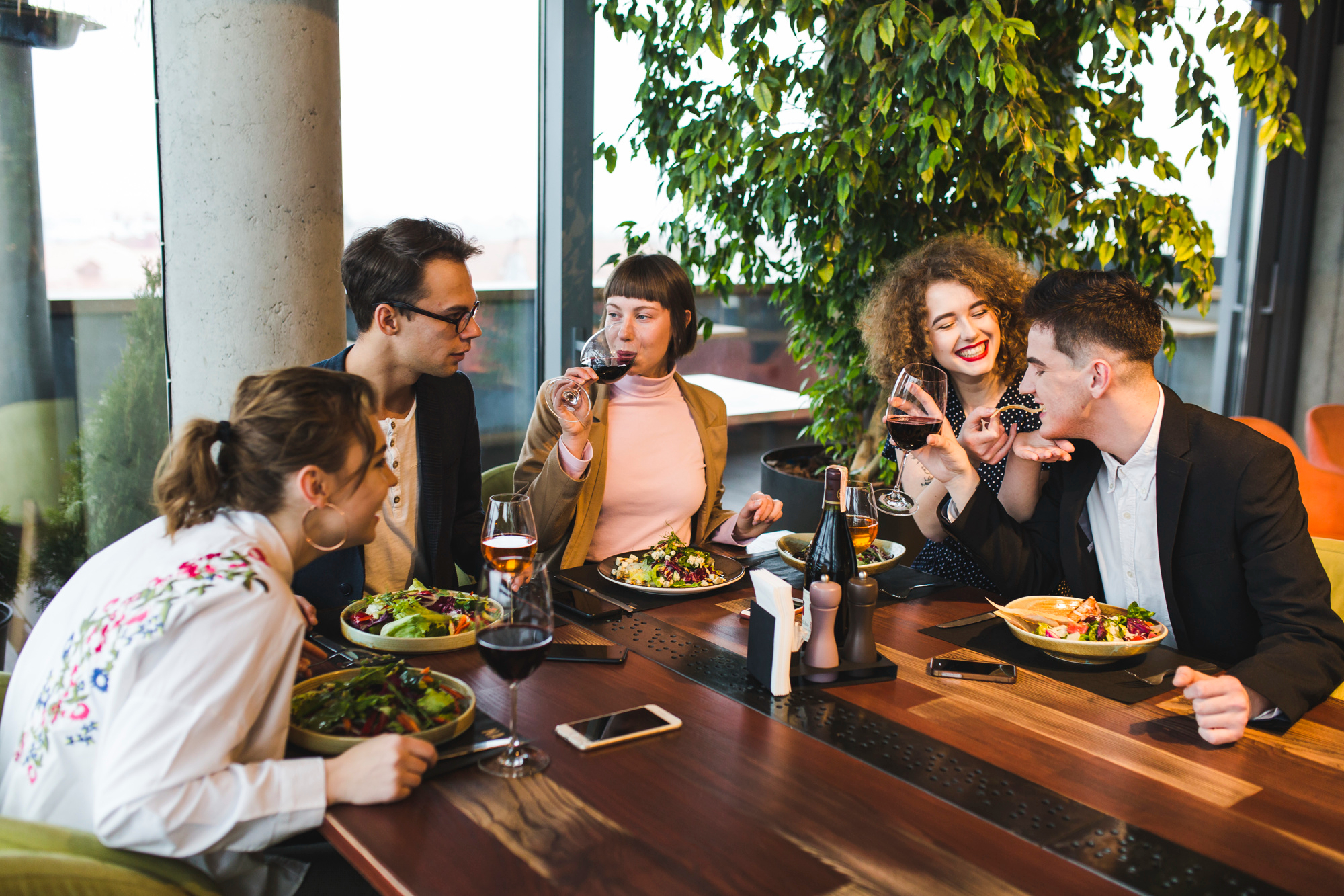 Un grupo de amigos comiendo en un restaurante | Foto: Freepik