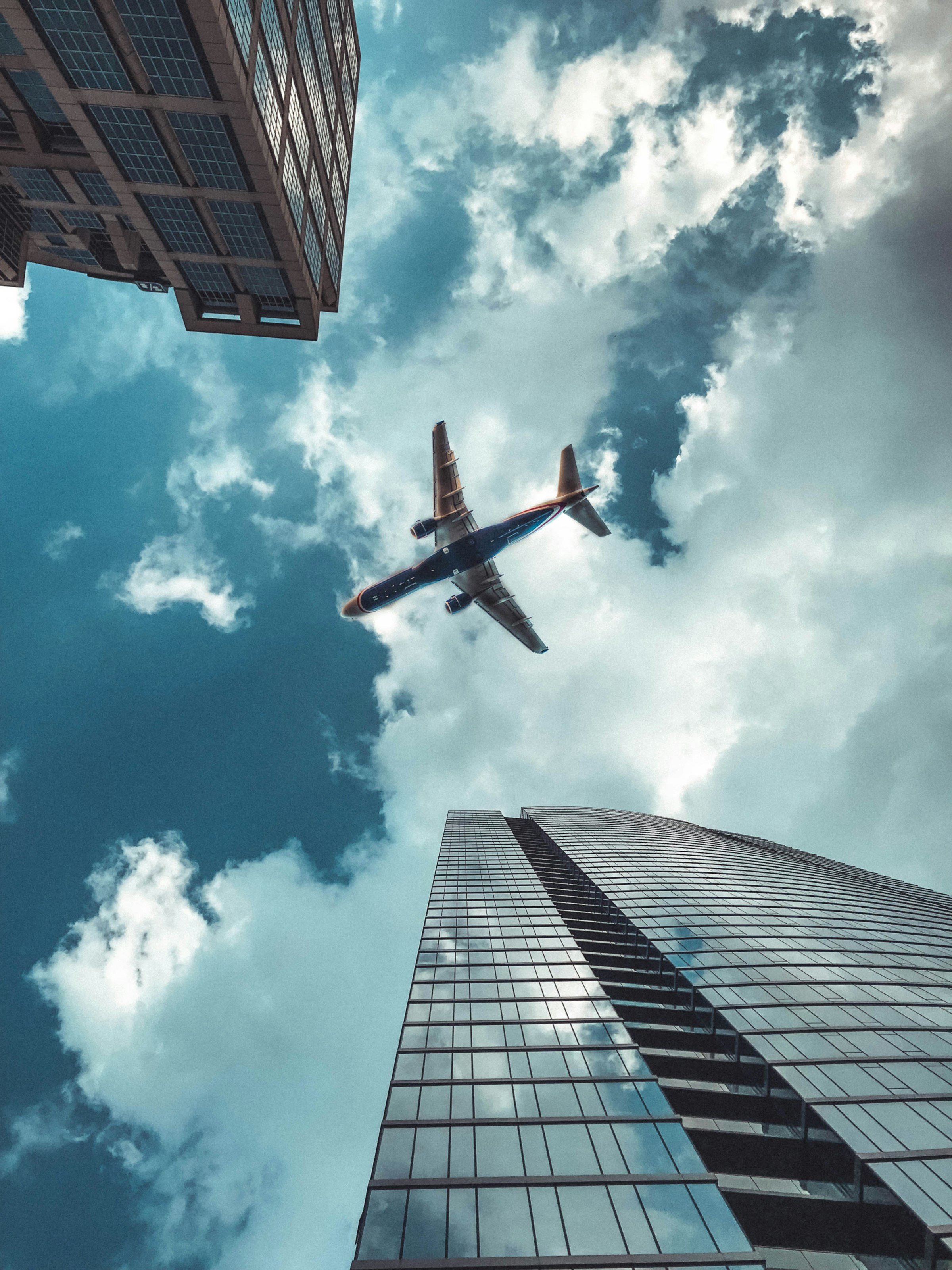 Toma de un avión pasando por encima de edificios altos | Fuente: Unsplash