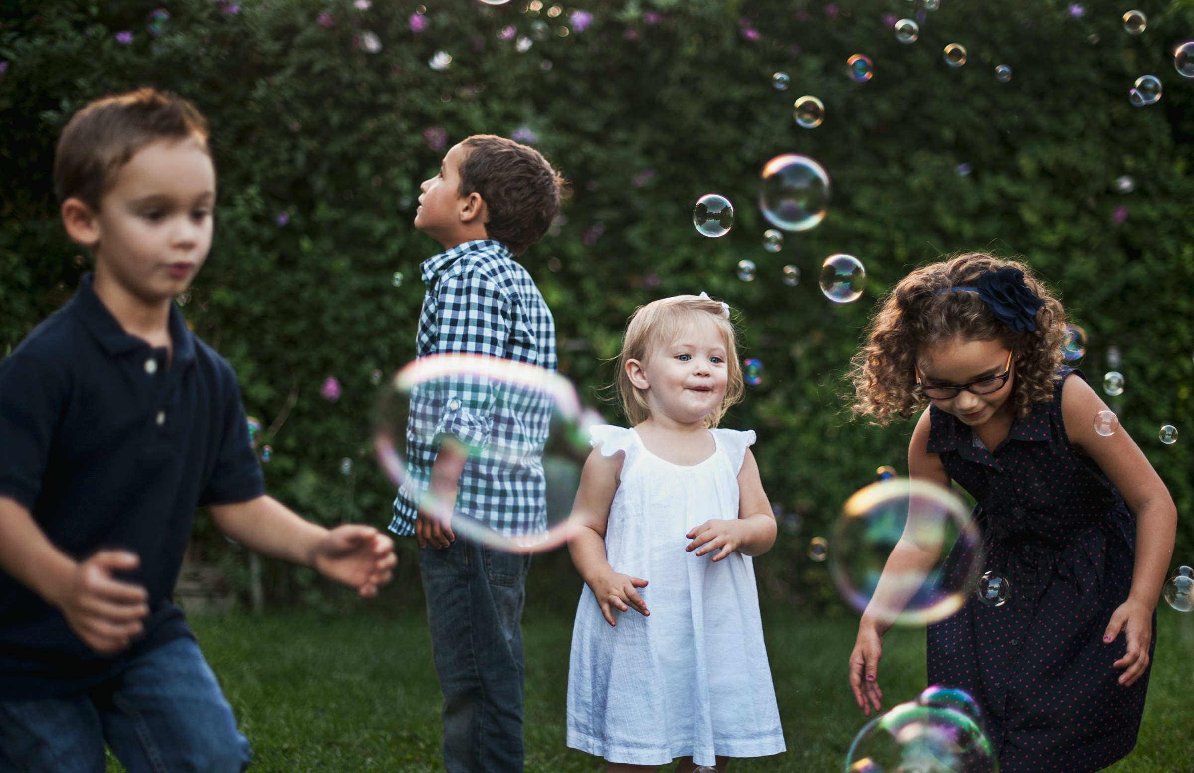 Niños jugando con burbujas al aire libre | Fuente: Unsplash