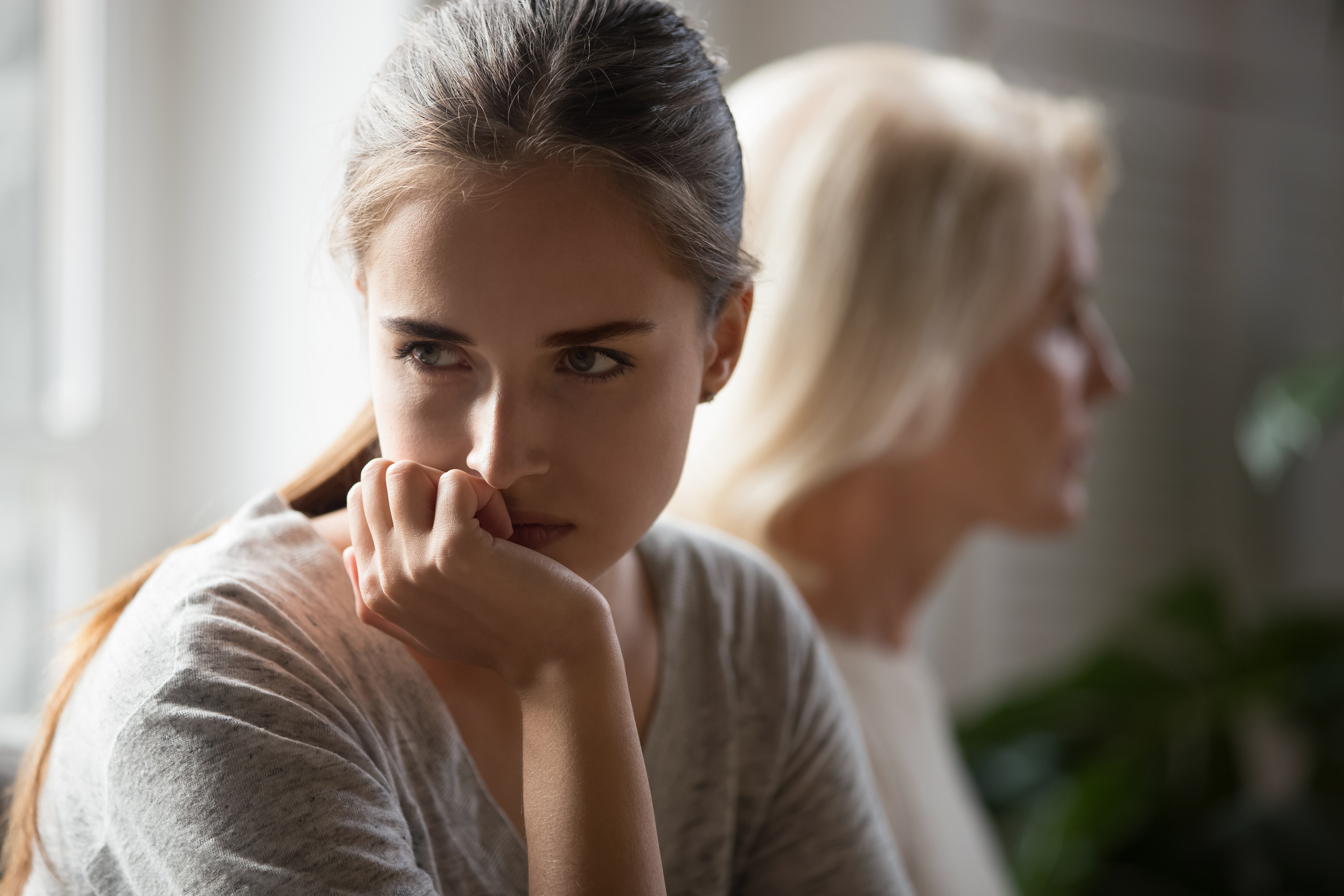 Hija y madre enfadadas se ignoran tras una pelea | Fuente: Shutterstock