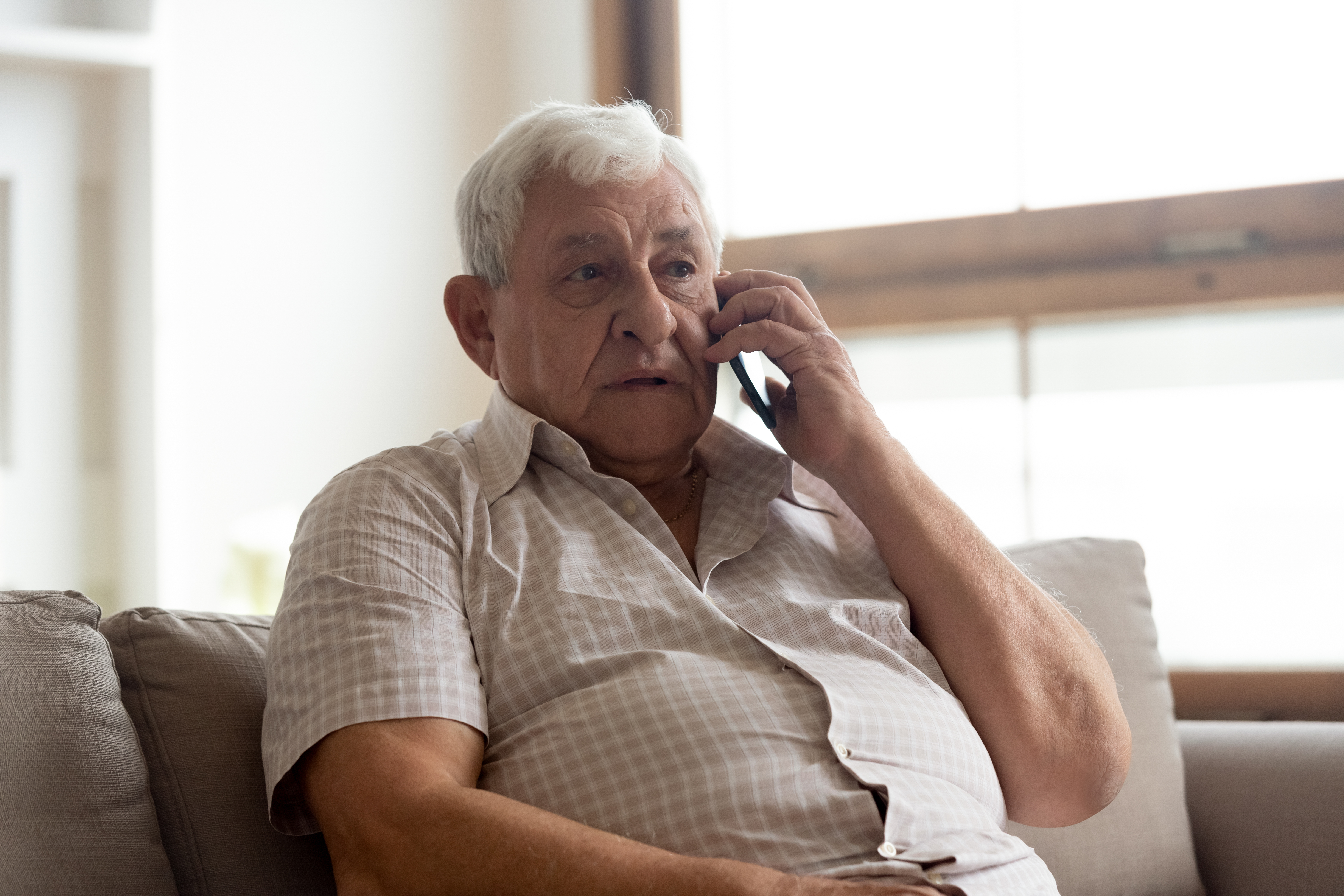 Un hombre mayor hablando por teléfono | Fuente: Shutterstock