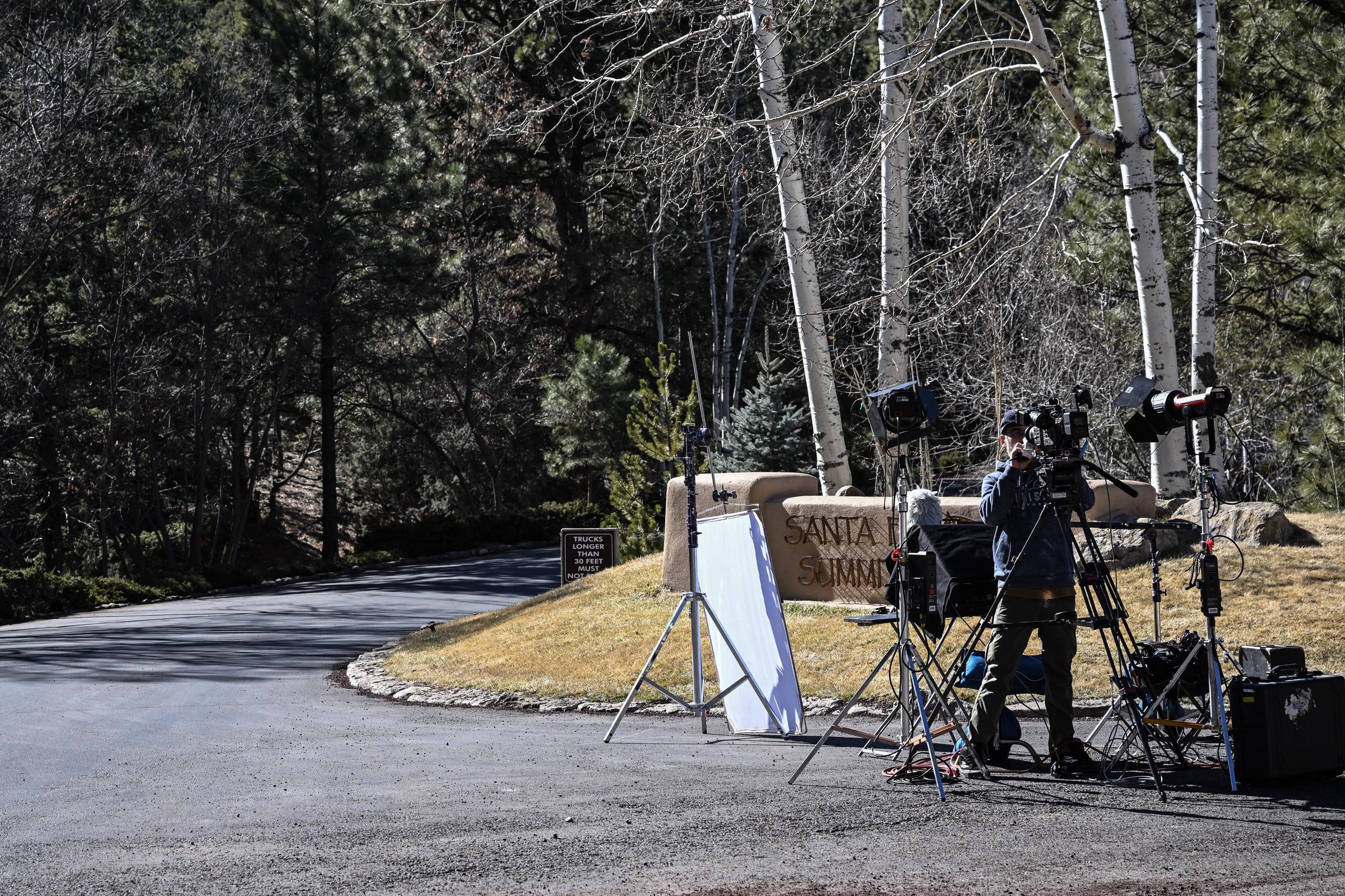 Un reportero coloca cámaras a la entrada del Vecindario Cumbre de Santa Fe, donde vivió Gene Hackman, el 28 de febrero de 2025 | Fuente: Getty Images