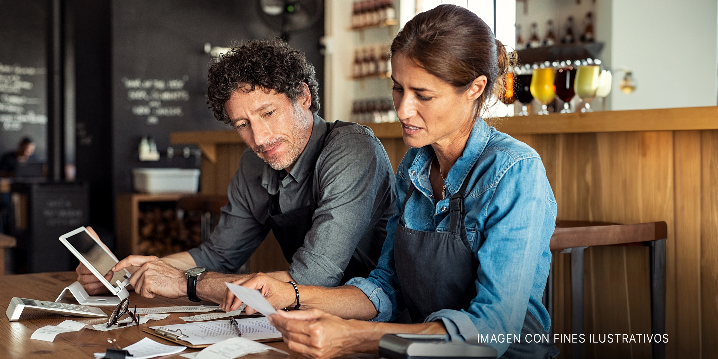Un hombre y una mujer parecen estresados mientras calculan recibos | Foto: Shutterstock