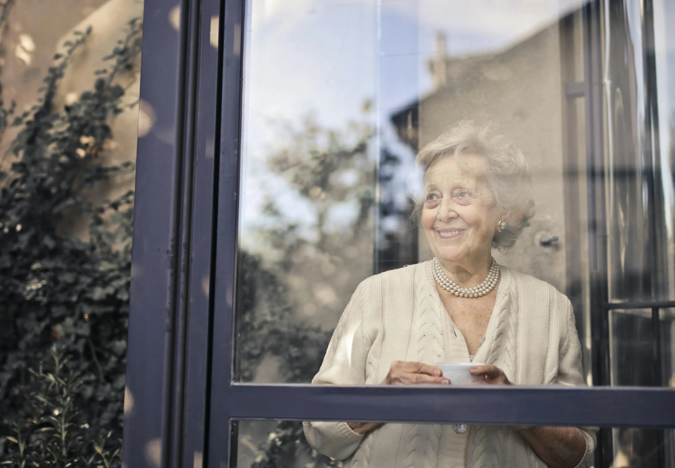 Una mujer sonriente bebiendo una taza de té ⏐ Fuente: Pexels