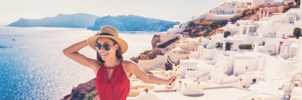 Mujer paseando por Santorini, Oia, islas griegas, durante sus vacaciones de lujo. Fuente: Shutterstock
