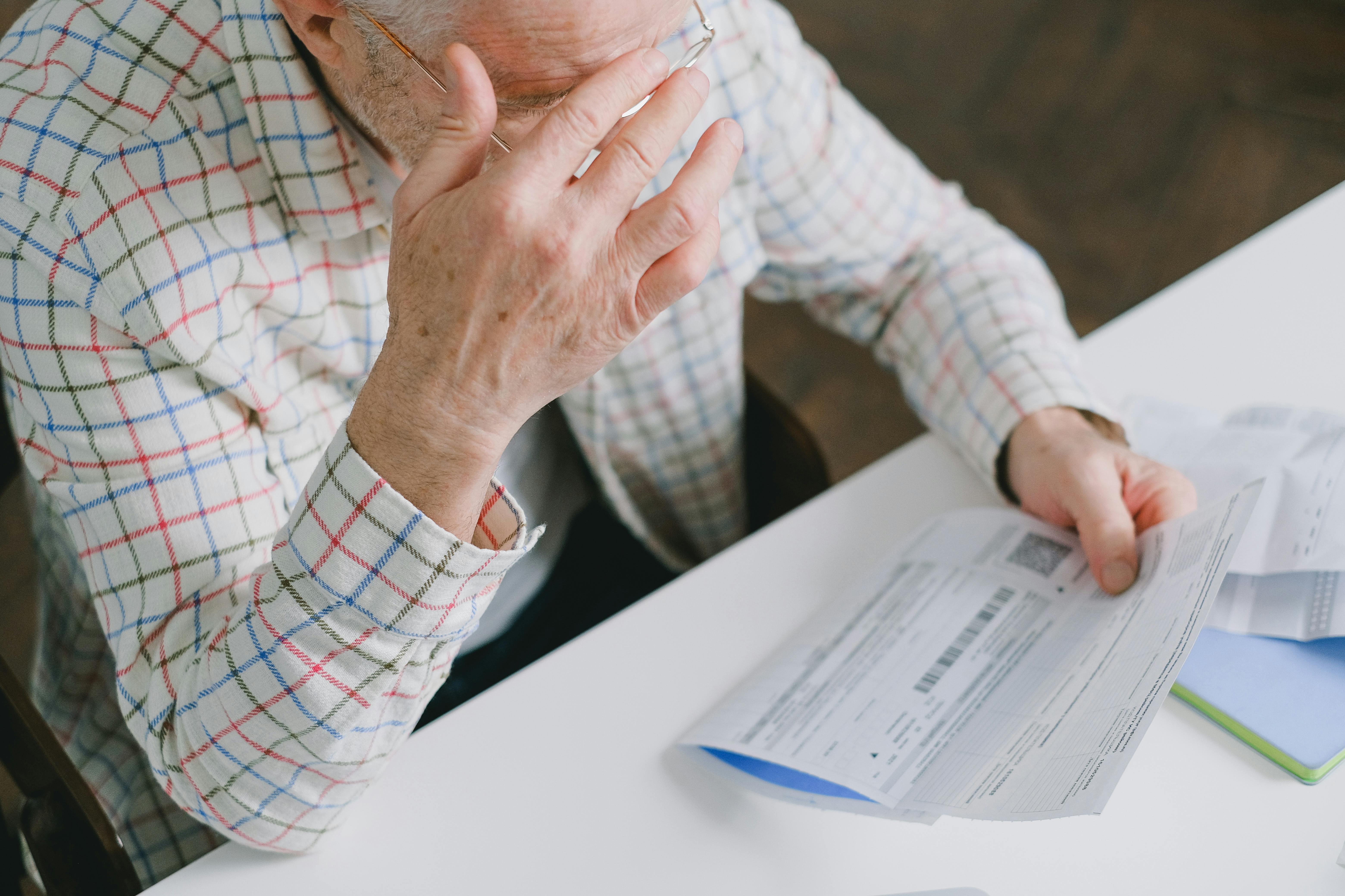 Un anziano con in mano un foglio di carta | Fonte: Pexels