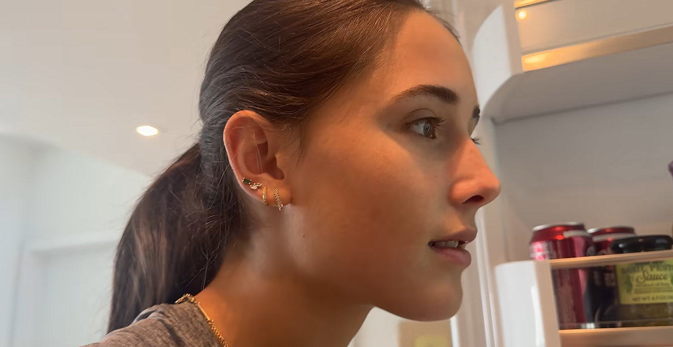 Emma, una amiga de Kai Trump, echa un vistazo al interior de su nevera mientras graba un vlog sobre su enfermedad. Emma eligió alimentos fáciles de preparar, como pasta, pan y fruta, para ayudarla durante su recuperación. | Fuente: YouTube/kaitrump