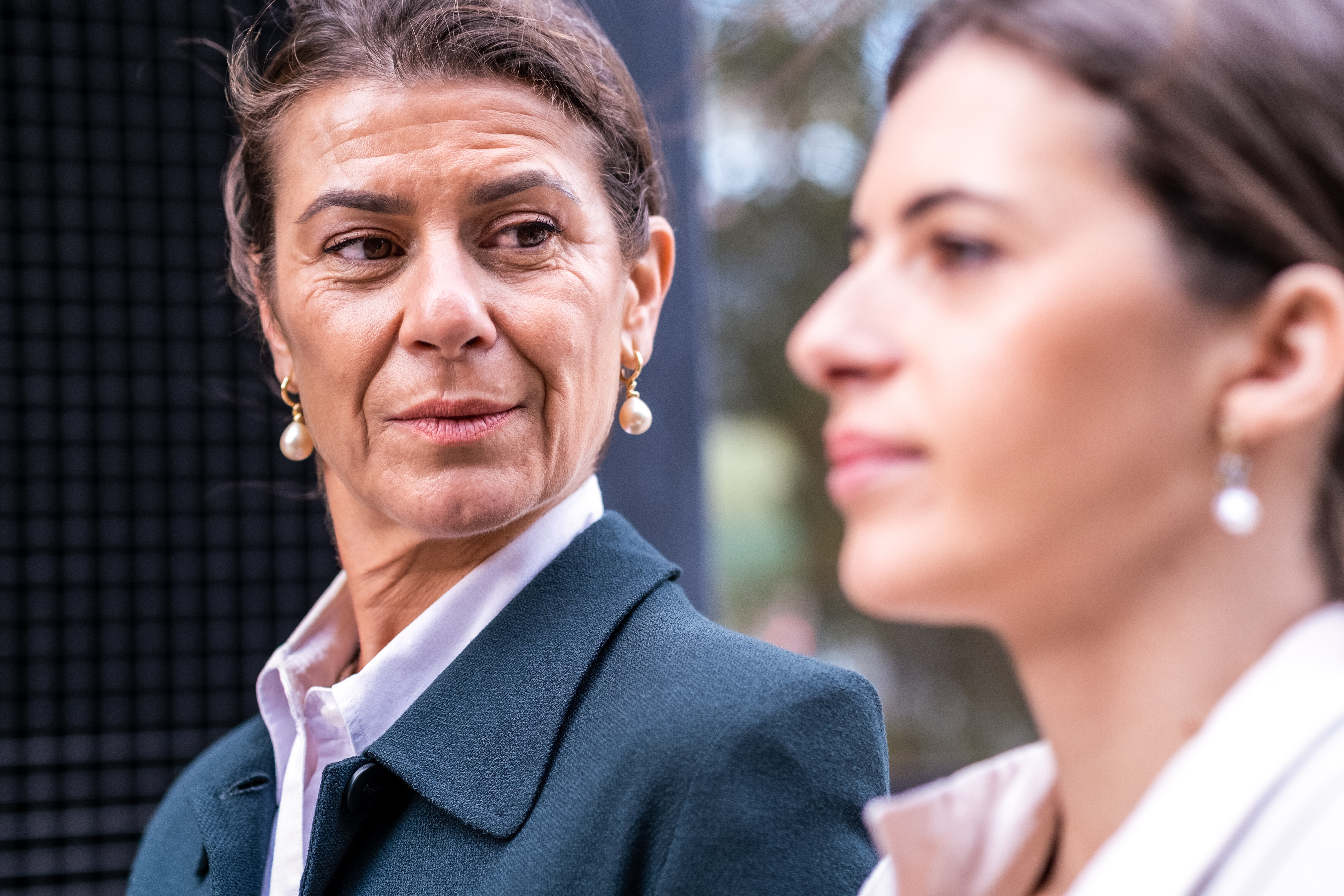 Mujer de negocios madura y adinerada con una hija de mediana edad manteniendo una conversación tranquila en un lugar al aire libre de una ciudad de primera categoría sobre negocios familiares | Fuente: Getty Images