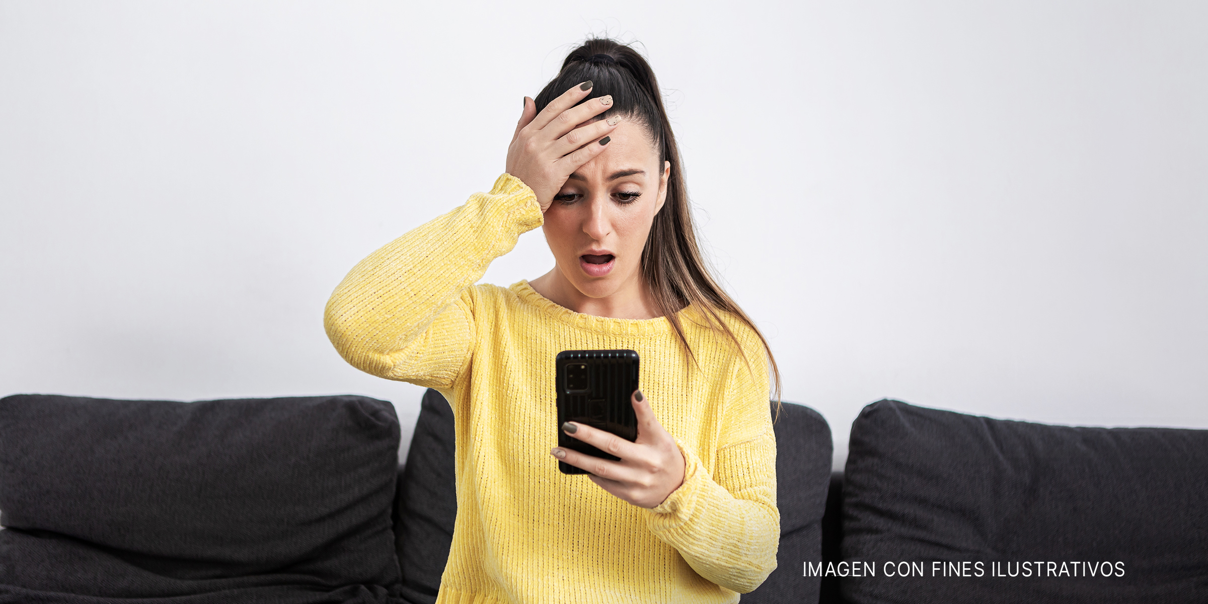Una mujer se sobresalta mientras mira la pantalla de su móvil | Foto: Getty Images