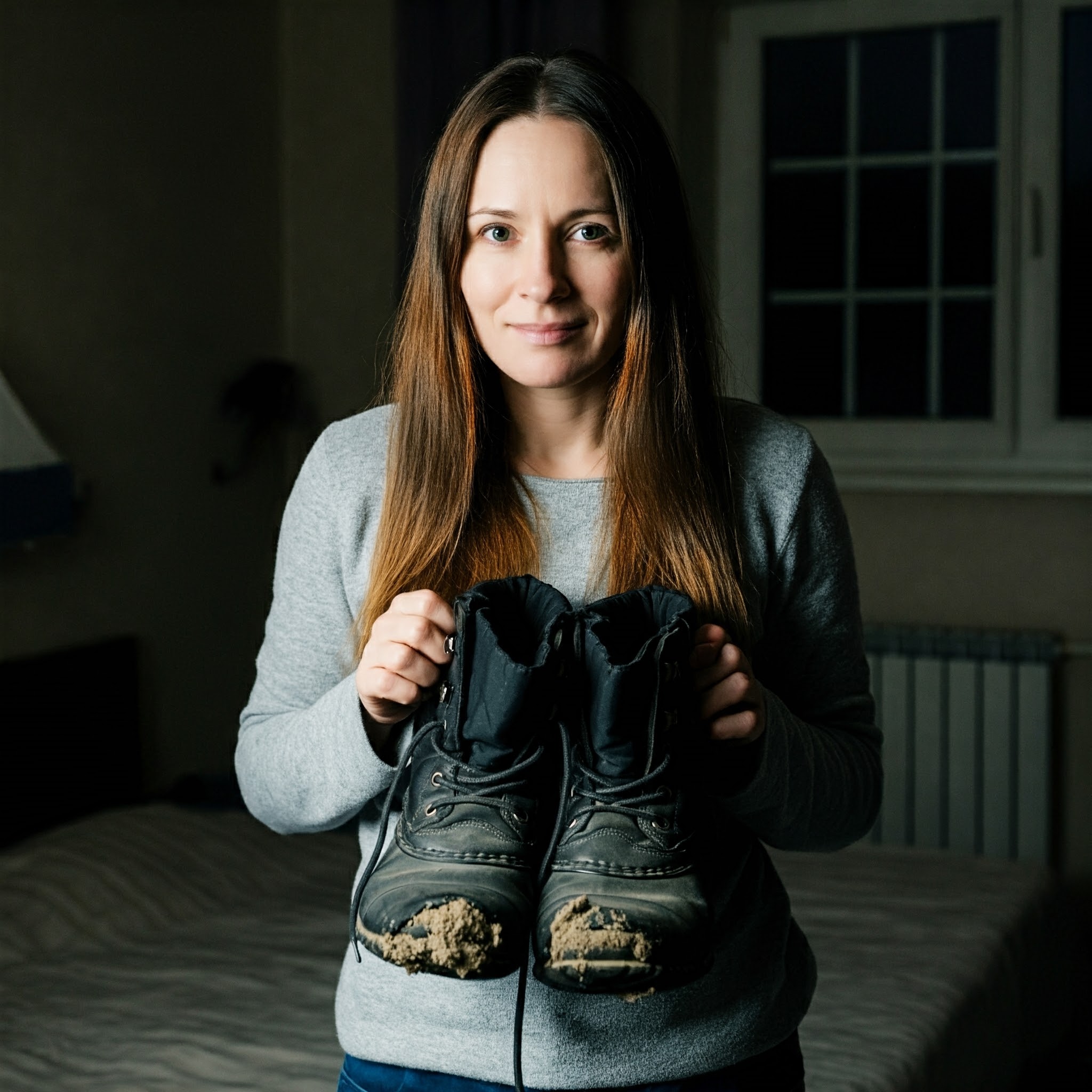 Una mujer sujetando unas botas de invierno desgastadas | Fuente: Gemini