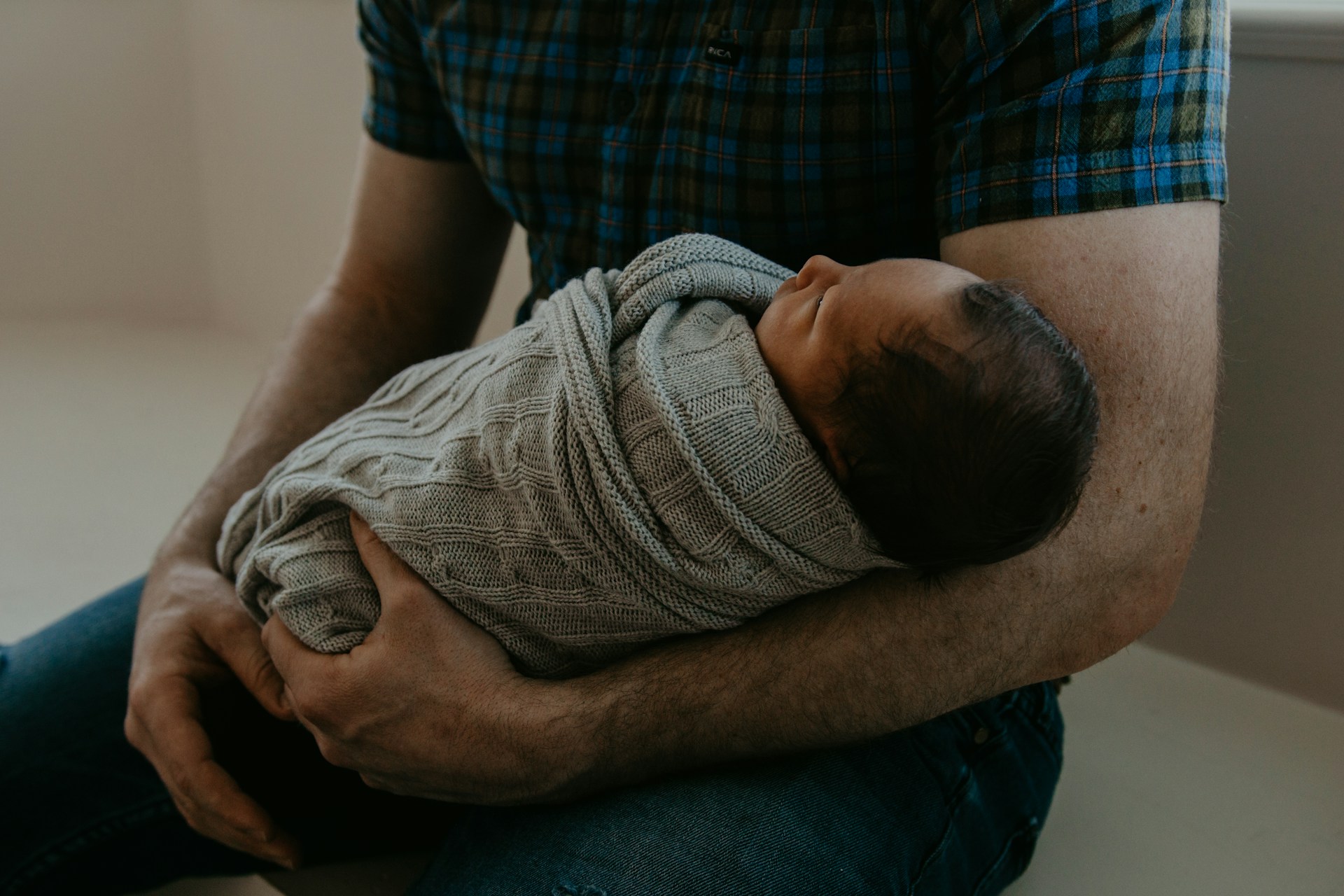 Un hombre con su bebé en brazos | Fuente: Unsplash