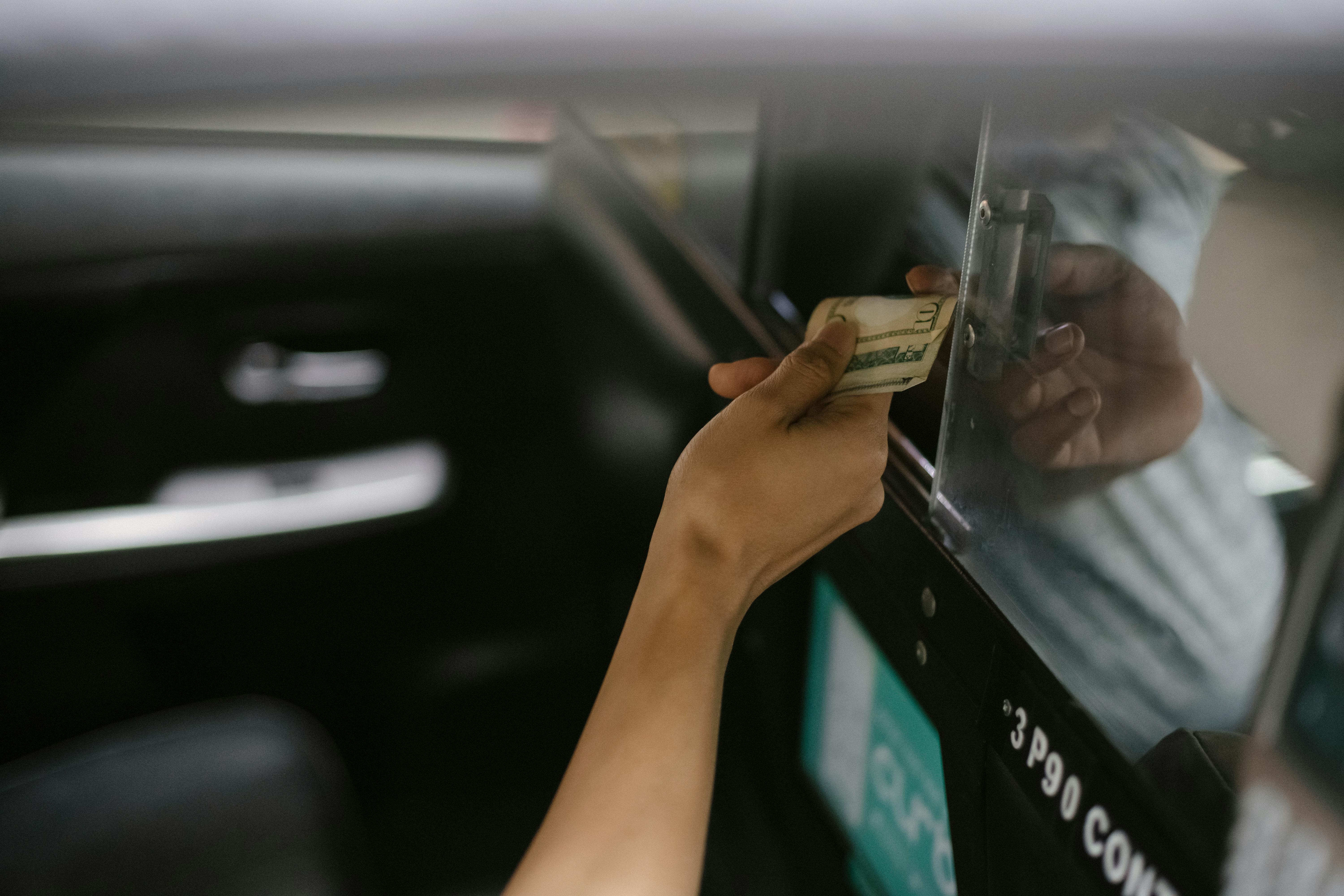 Una mujer pasando dinero a un taxista | Fuente: Pexels