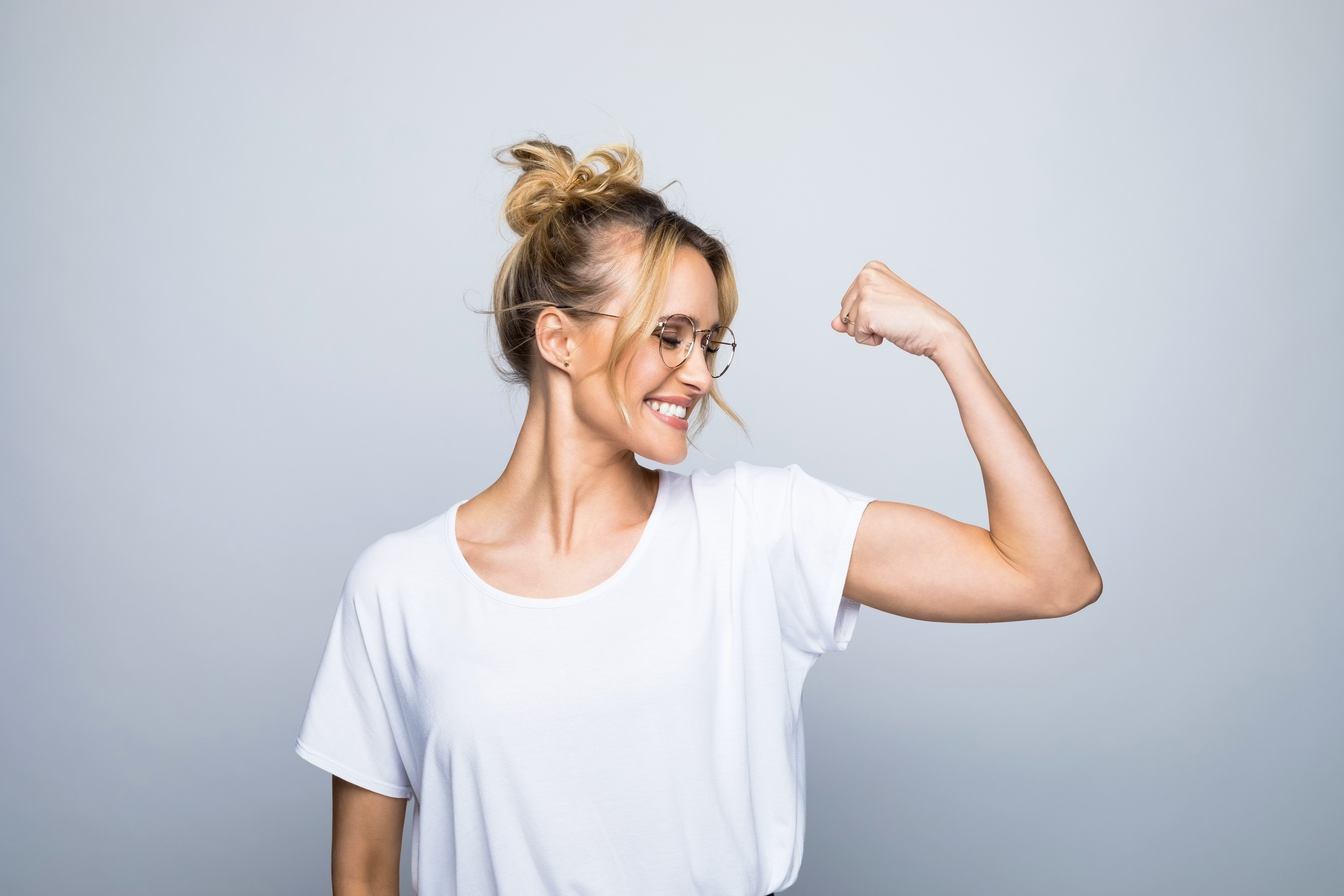 Mujer guapa y feliz flexionando los músculos | Foto: Getty Images