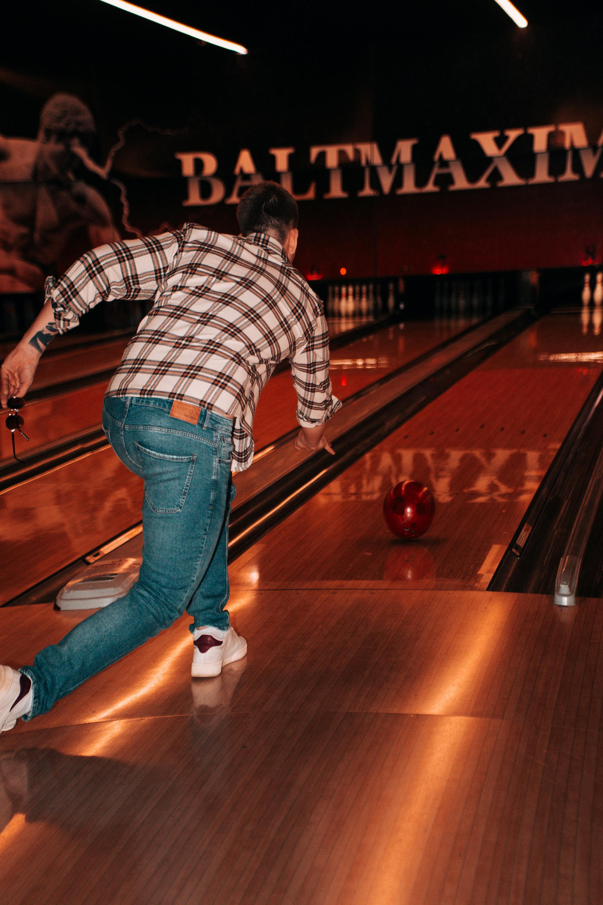 Vista trasera de un hombre lanzando una bola en una bolera | Fuente: Pexels