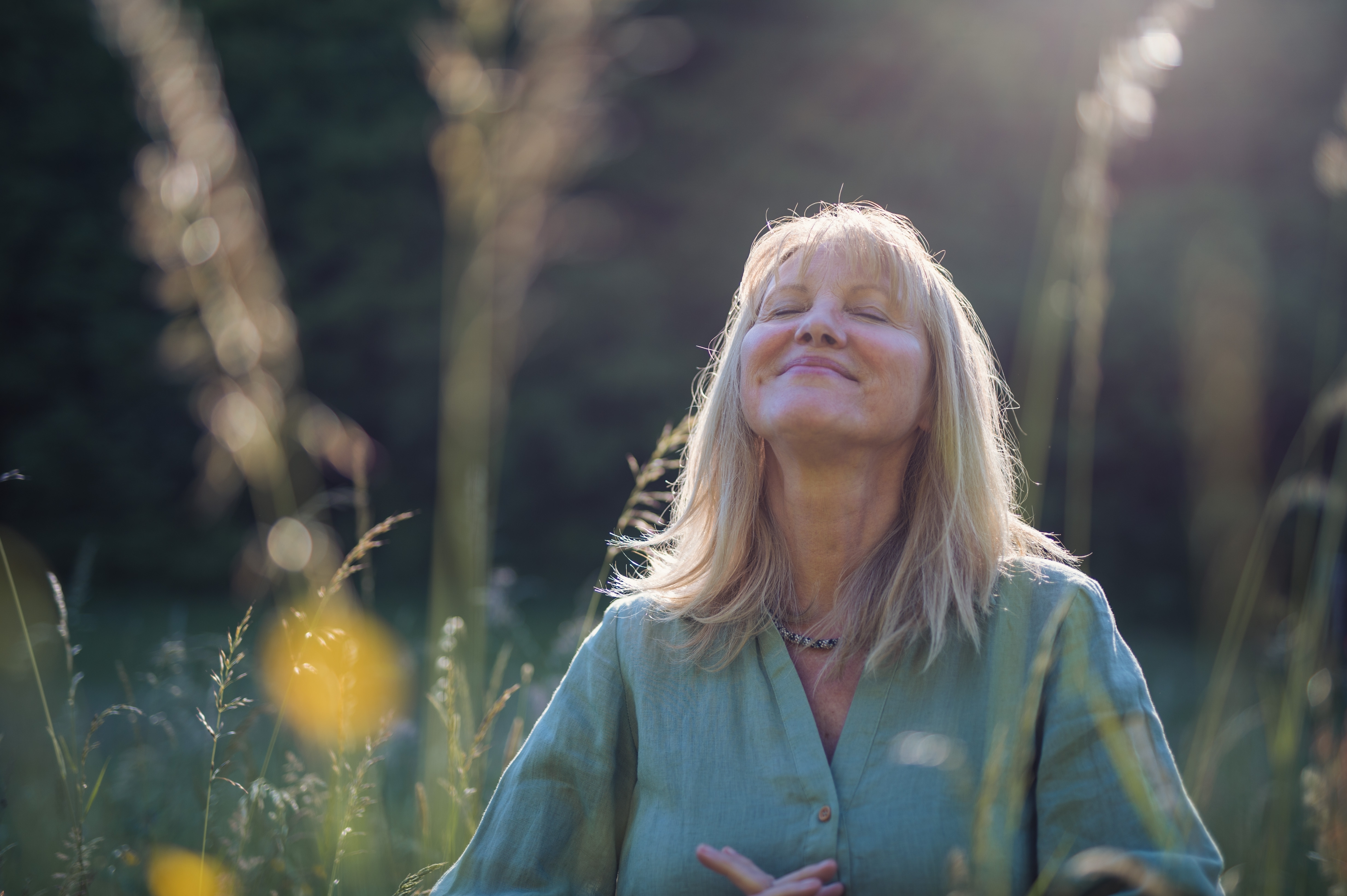 Una mujer tomándose un momento de tranquilidad rodeada de naturaleza | Fuente: Shutterstock