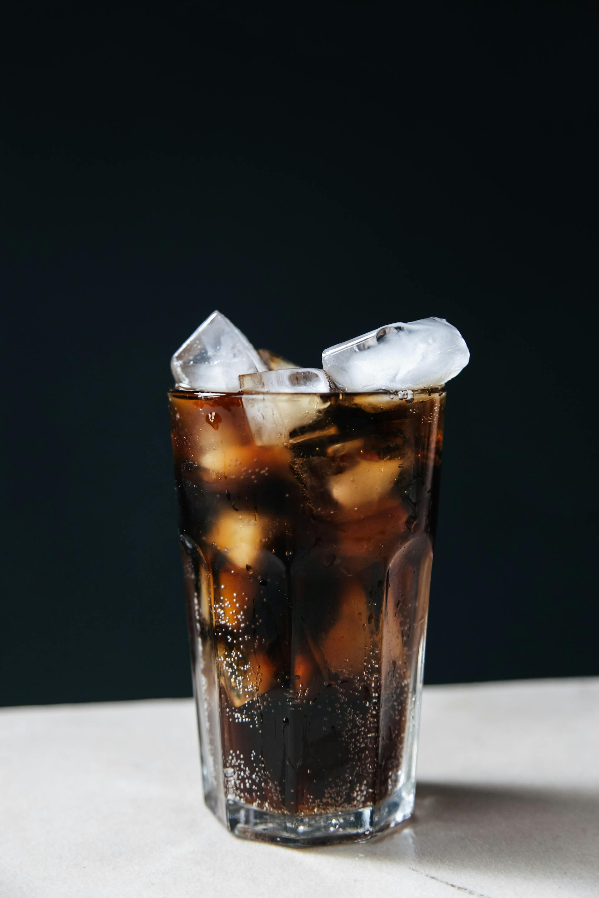 Un vaso de cola helada sobre una mesa | Fuente: Pexels