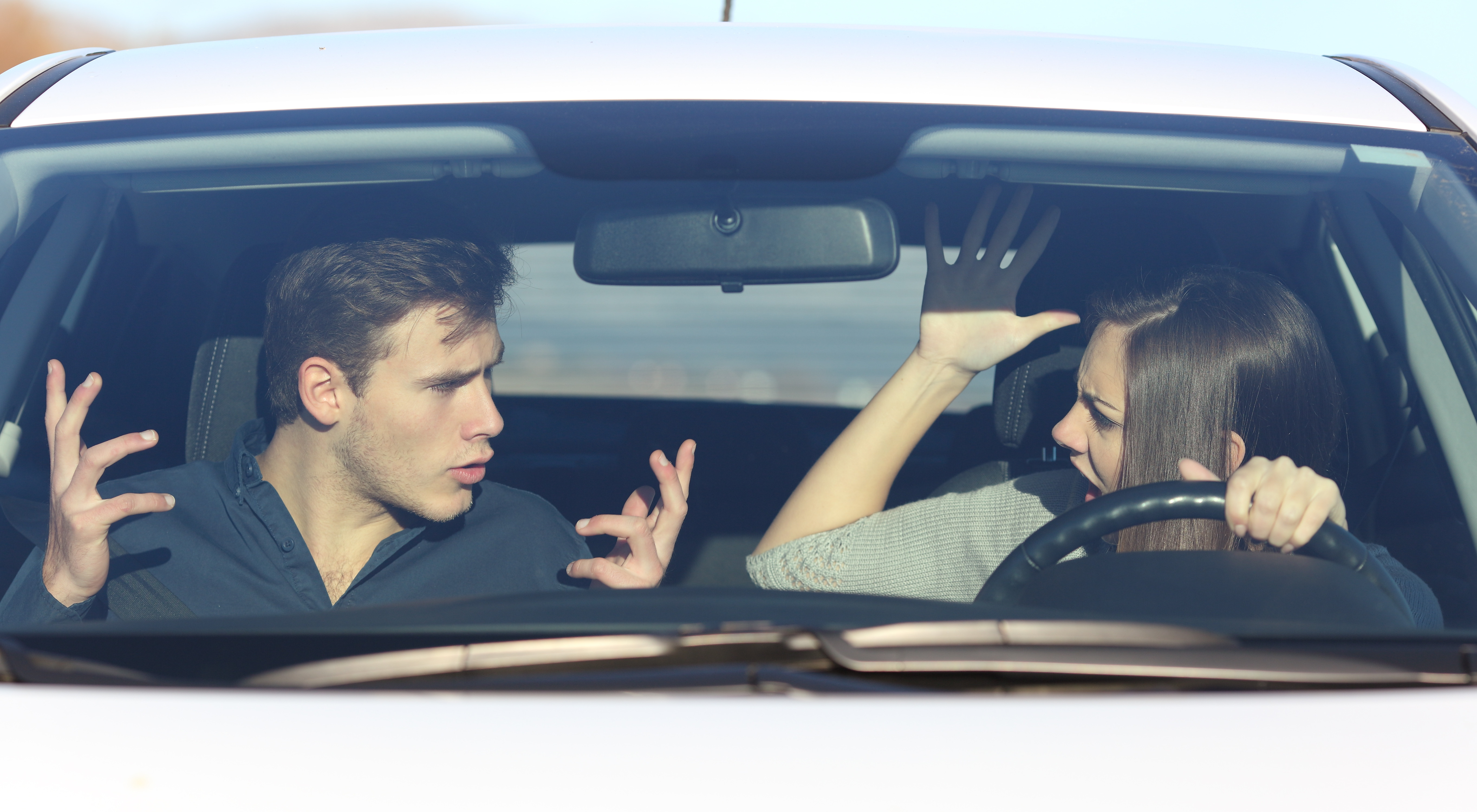 Pareja discutiendo mientras ella conduce un automóvil | Fuente: Getty Images