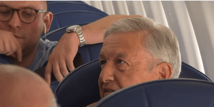 AMLO en compañía de dos personas, dentro del avión. | Imagen: YouTube / AFPES