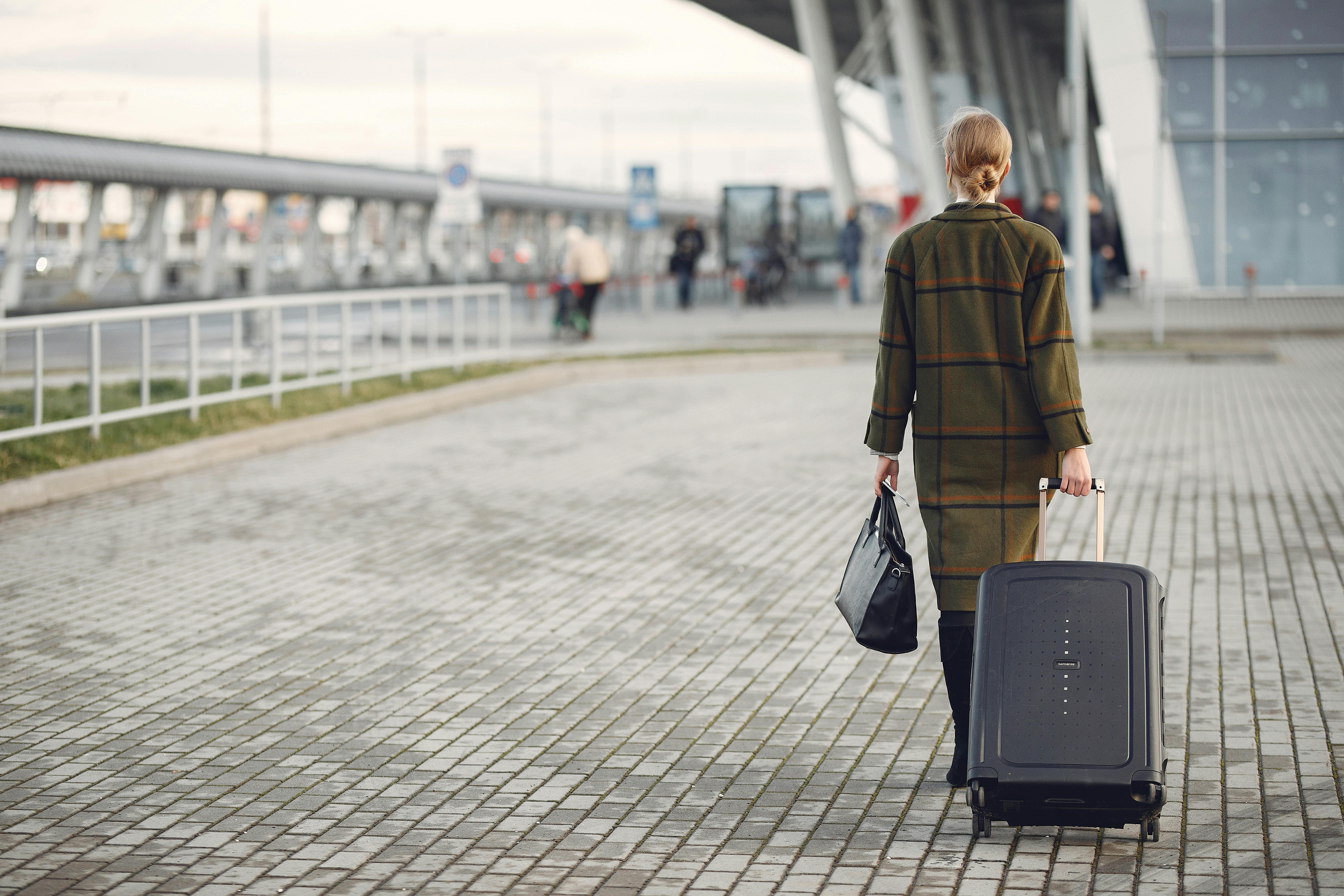 Una mujer alejándose con su equipaje | Fuente: Pexels