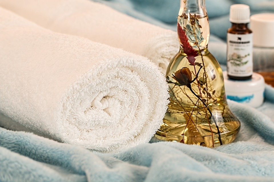 Botella de aceite sobre una mesa, junto a una toalla blanca. | Foto: Pixabay