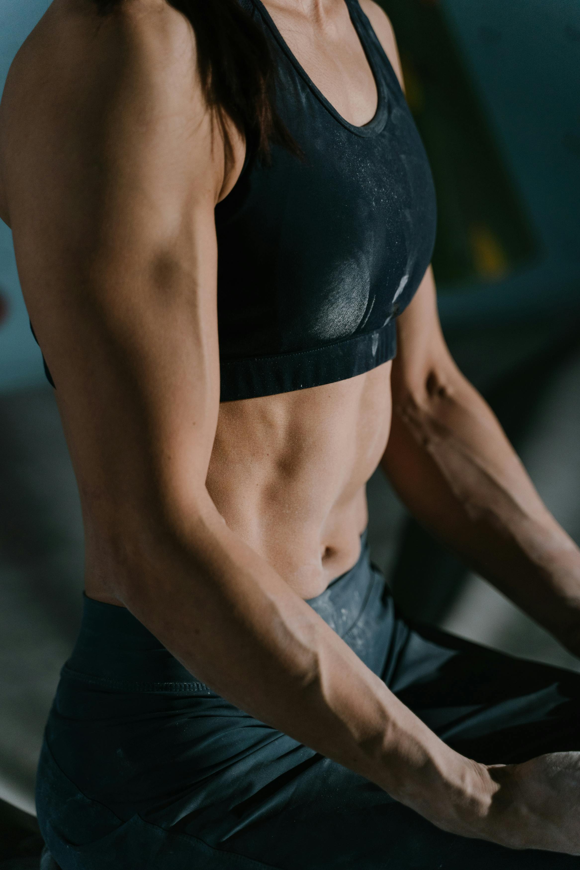 Una mujer musculosa sentada en un banco | Fuente: Pexels