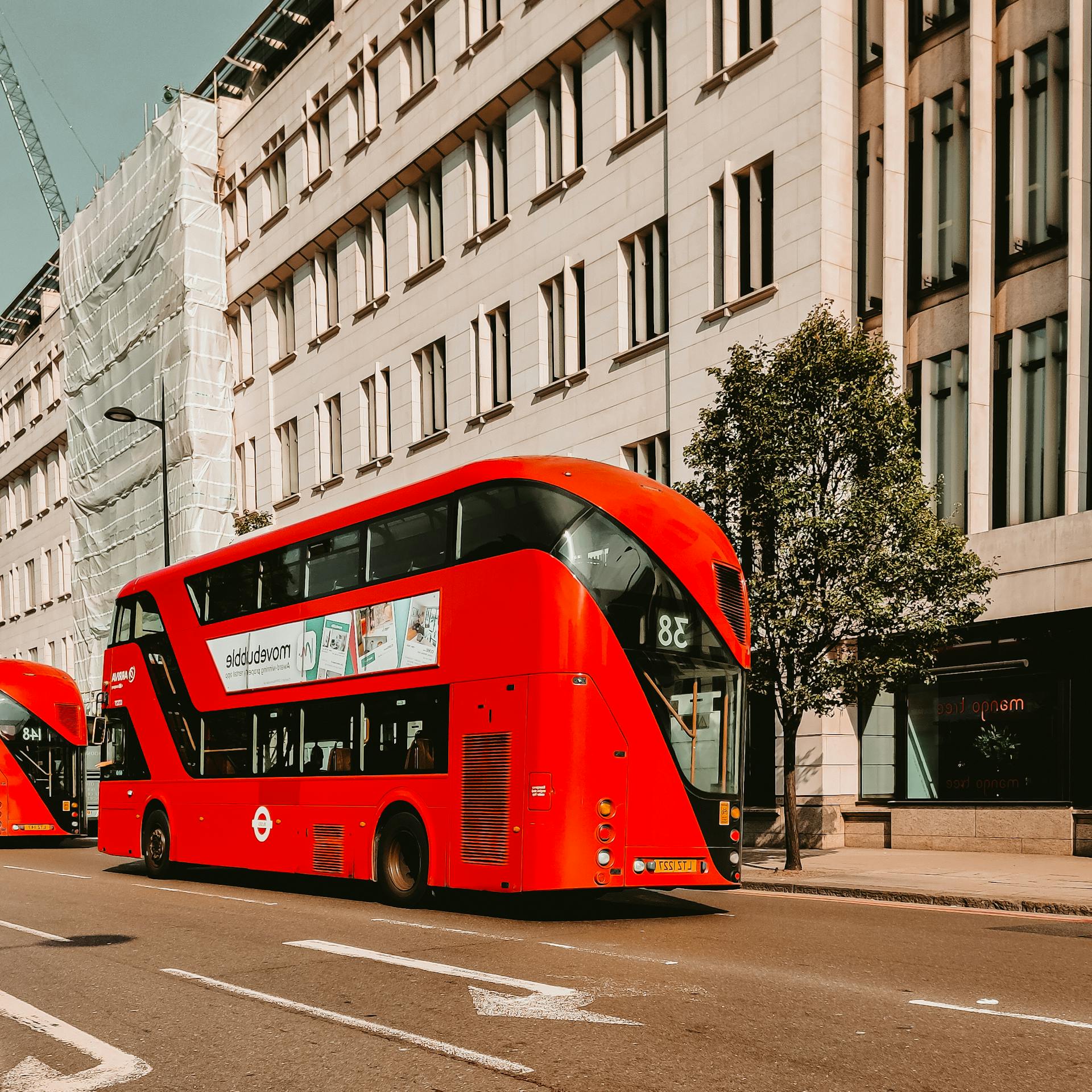 Un autobús rojo de dos pisos pasando por una calle de la ciudad | Foto: Pexels