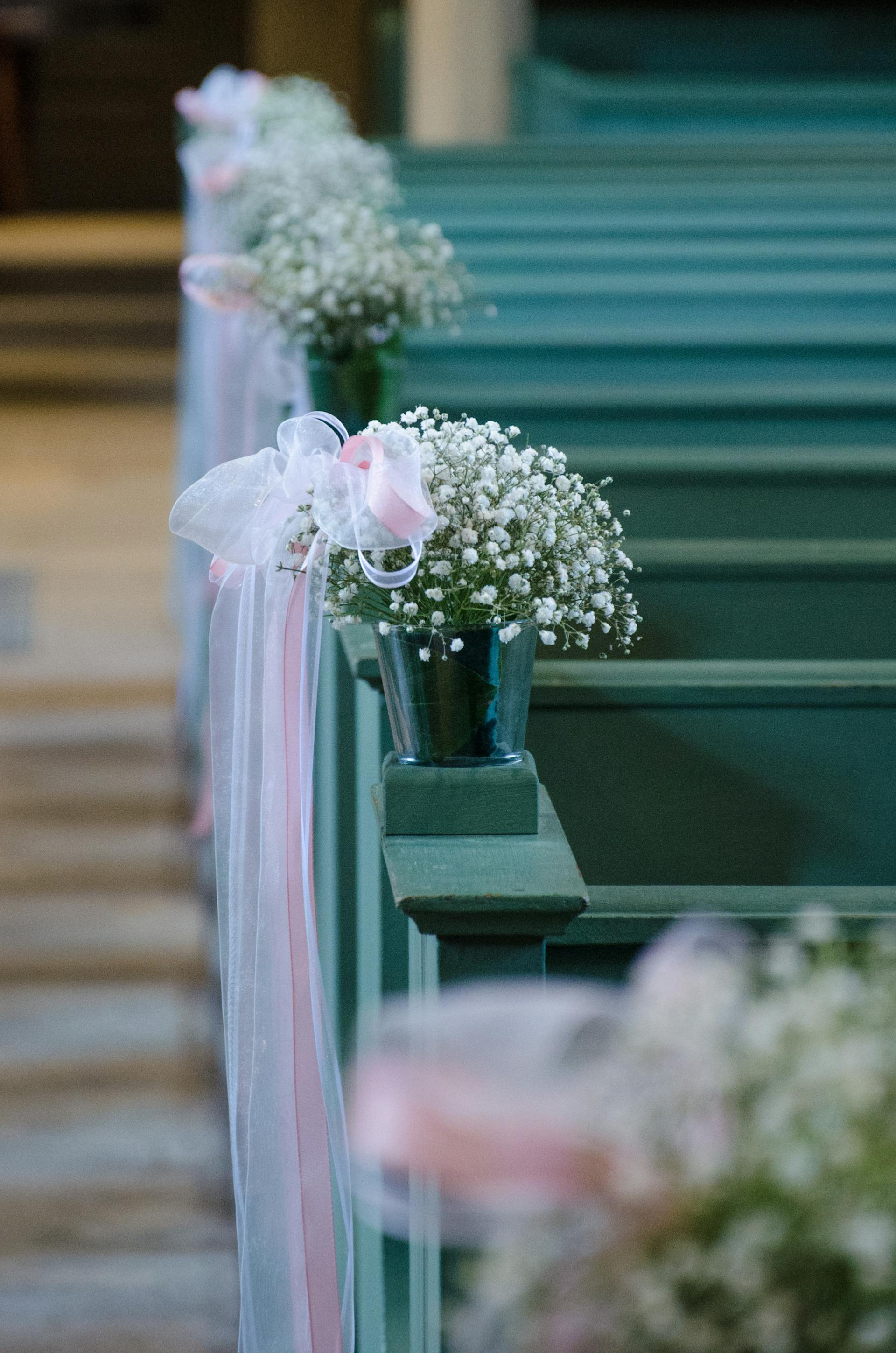 Flores y tul a lo largo de los bancos de una iglesia | Foto: Pexels