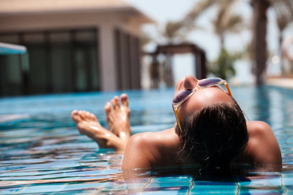 Mujer disfrutando de la piscina durante sus vacaciones. Fuente: Shutterstock