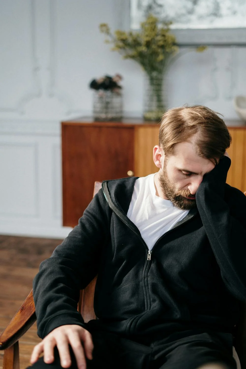 Un hombre triste frotándose la cara | Fuente: Pexels