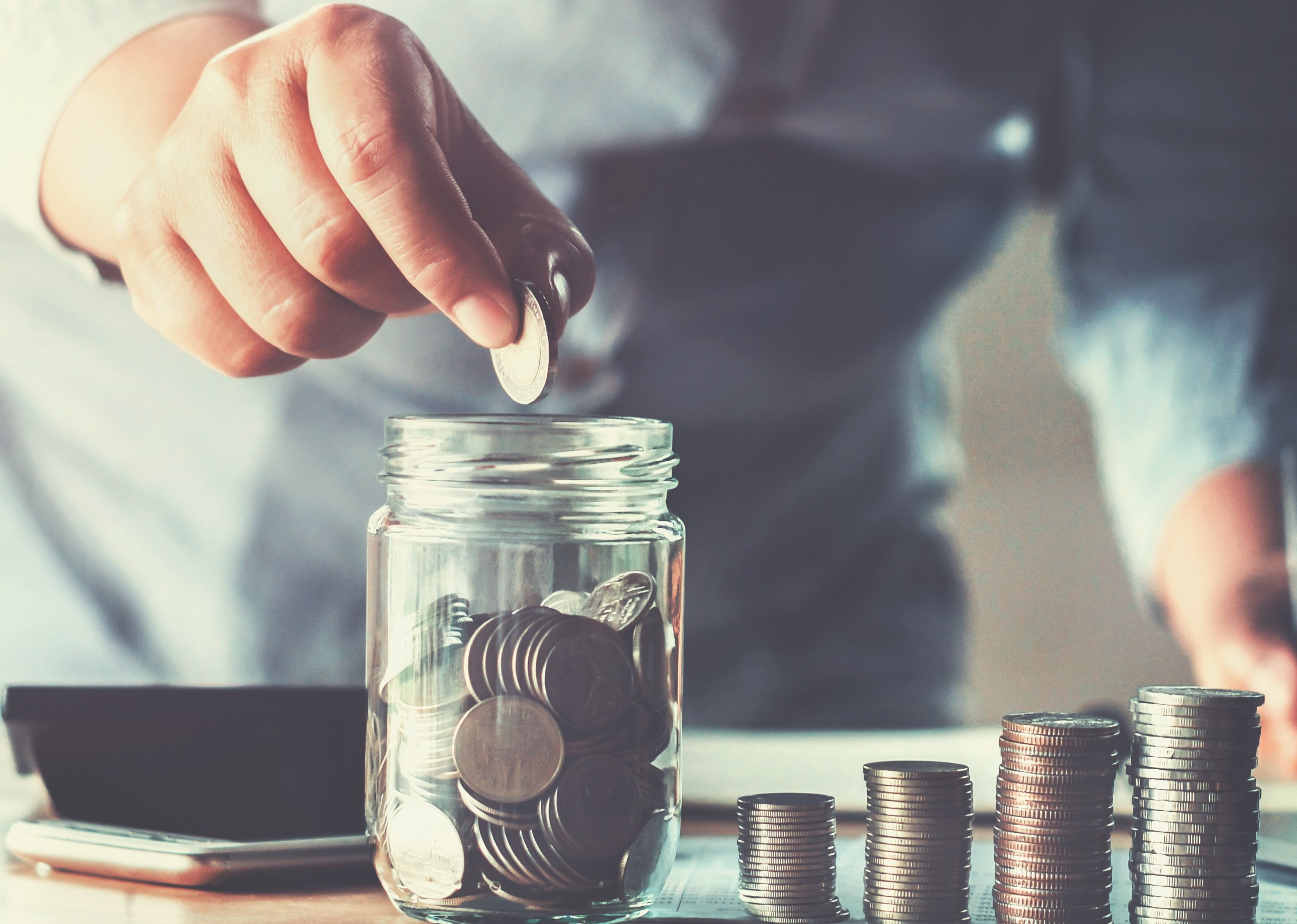 Persona contando monedas sobre una mesa. | Foto: Shutterstock