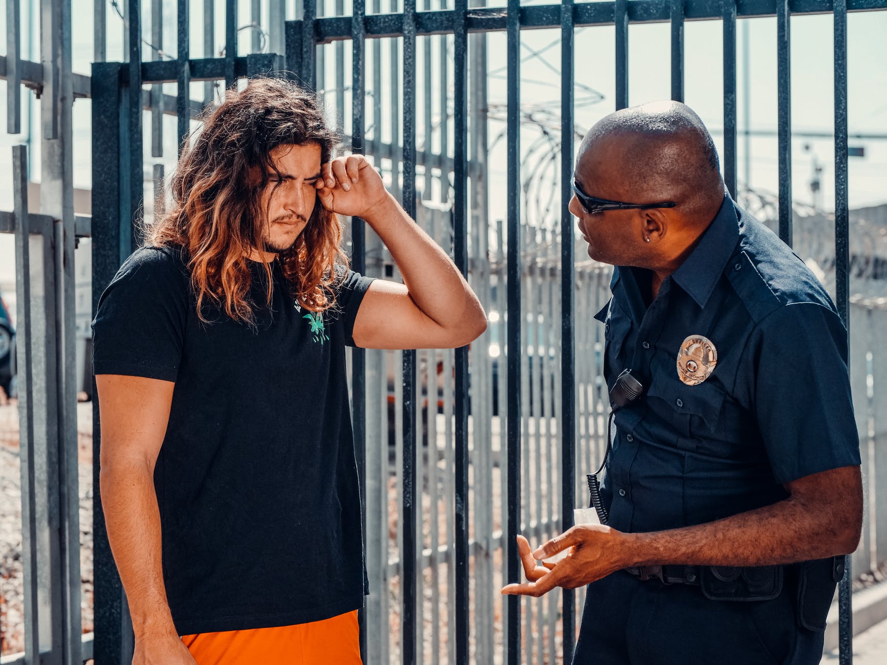 Un hombre con rostro afligido conversando con un oficial de policía. | Foto: Pexels