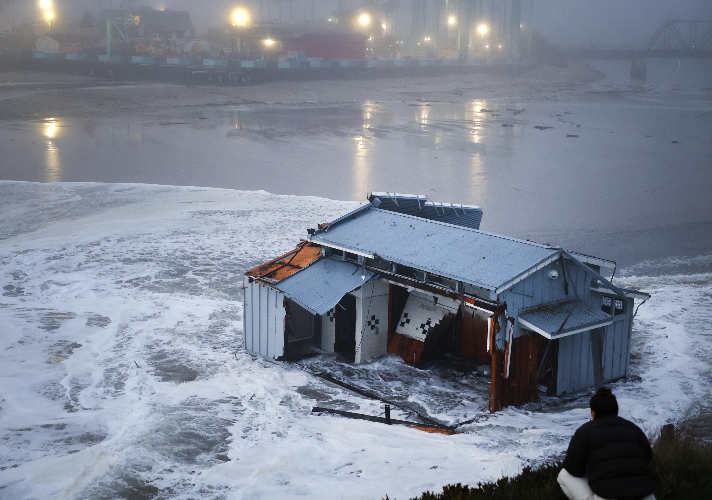 Un grupo de personas observa el muelle derrumbado en el embarcadero de Santa Cruz, California, el 23 de diciembre de 2024 | Fuente: Getty Images