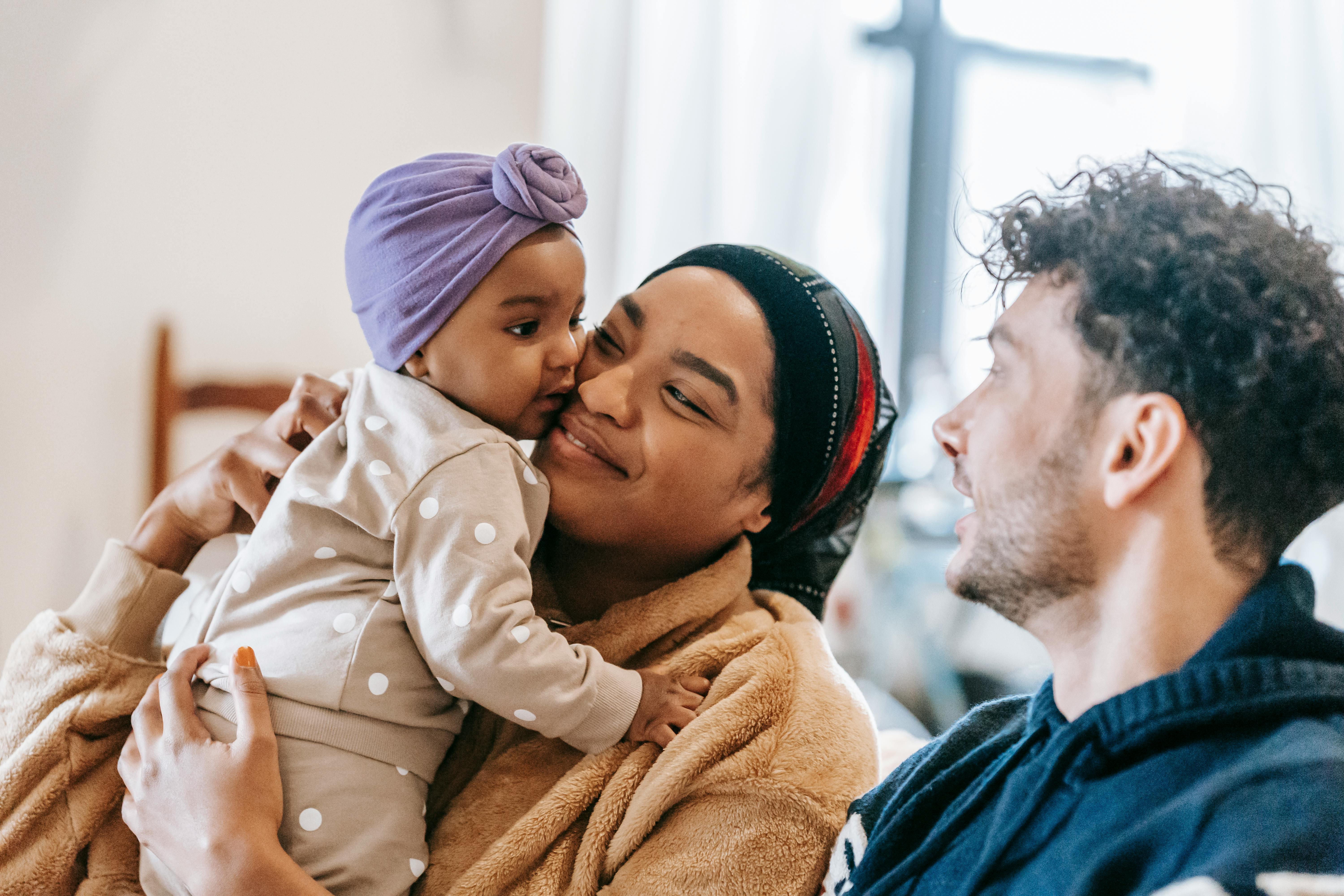 Una pareja feliz estrechando lazos con su hijo | Fuente: Pexels