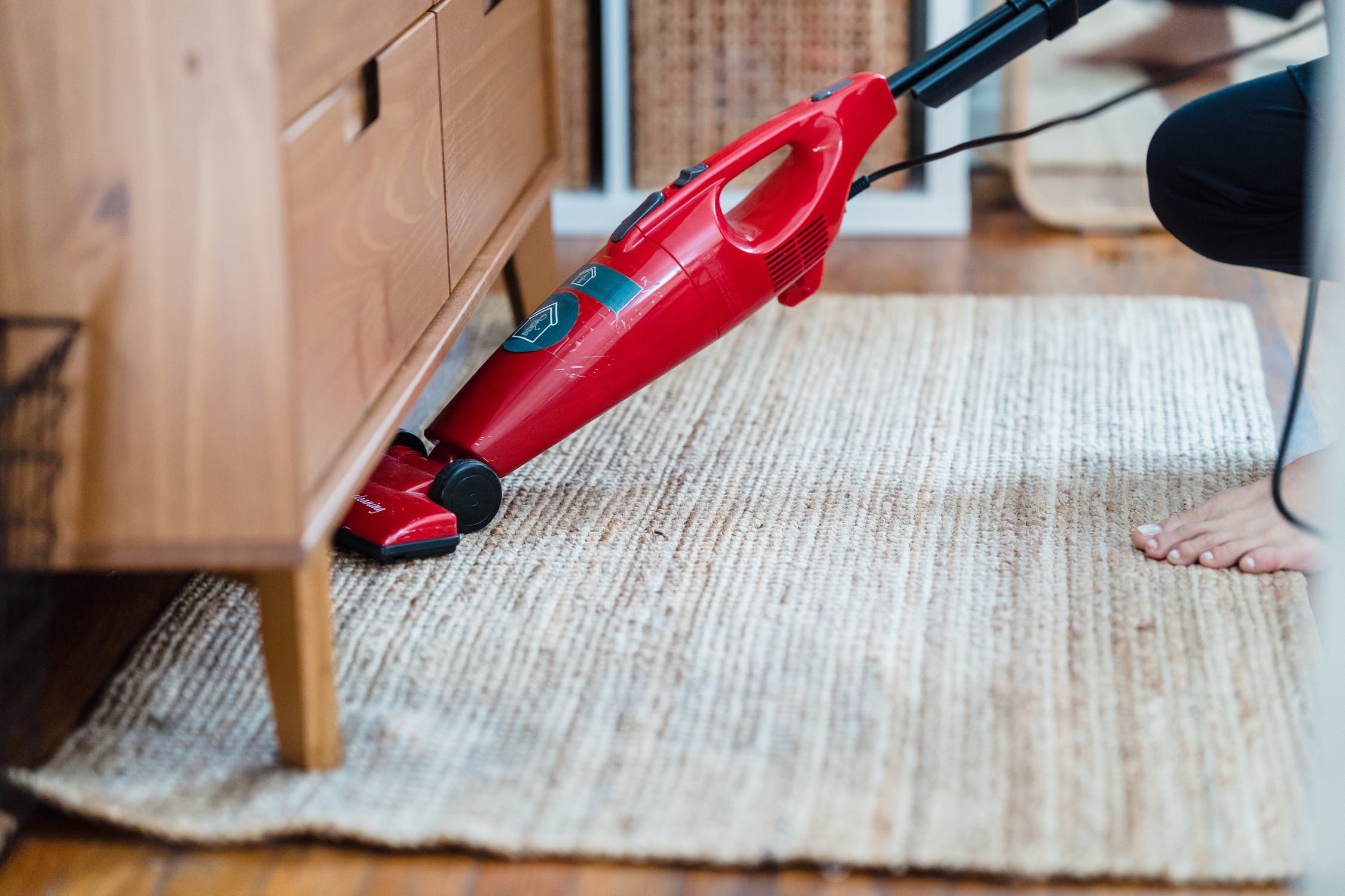 Mujer limpiando una alfombra con una aspiradora. | Foto: Unsplash