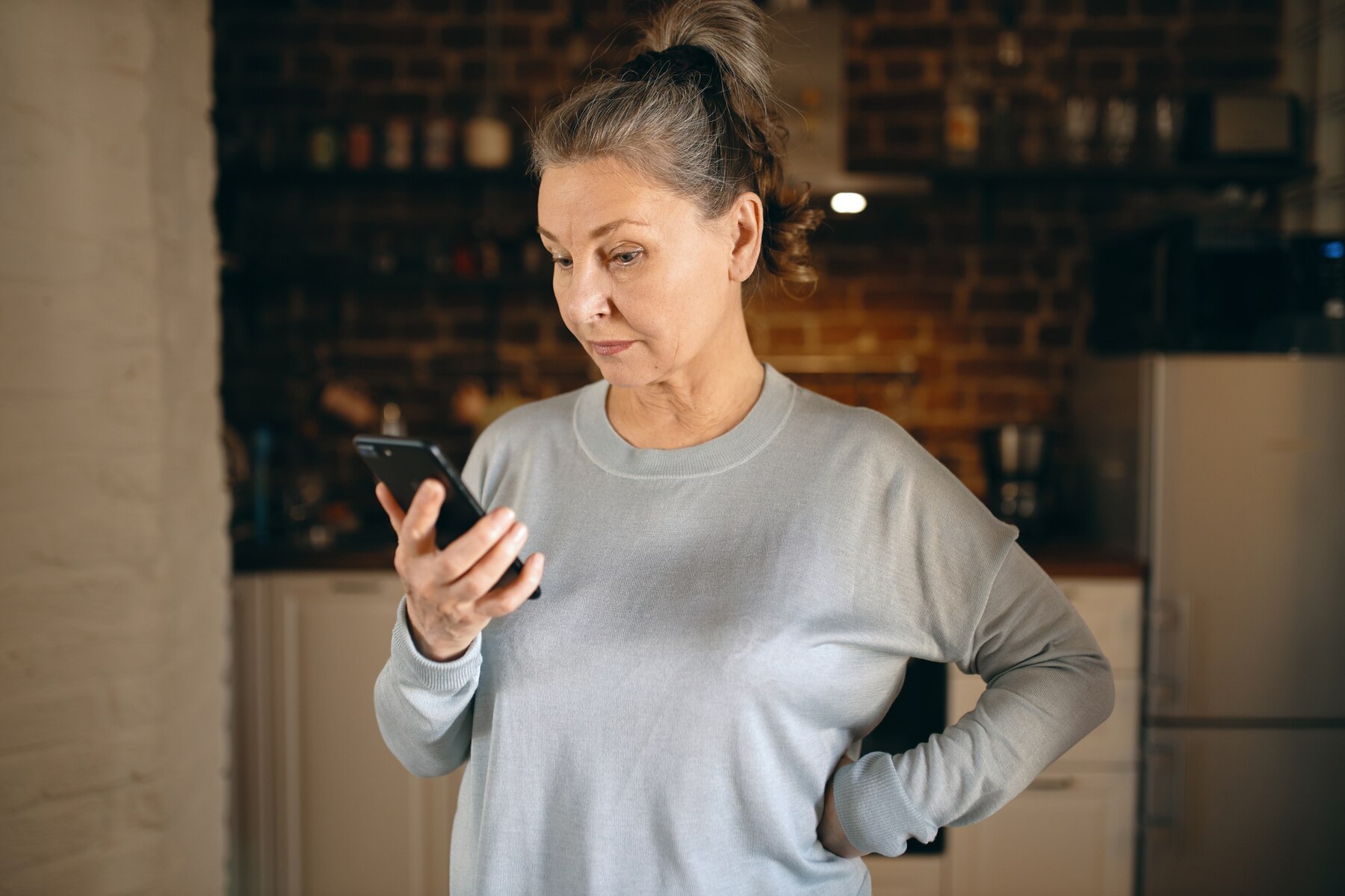 Una mujer de mediana edad enfadada mirando su teléfono | Fuente: Freepik