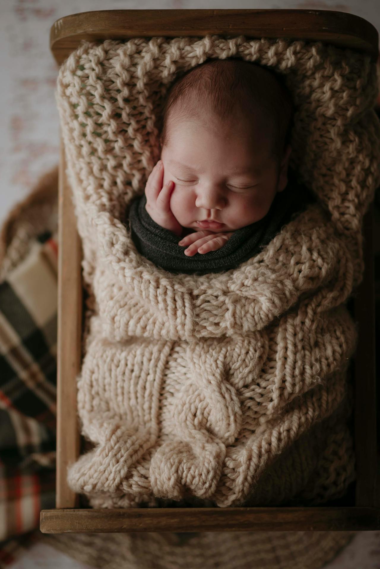 Un neonato avvolto in una coperta lavorata a maglia color crema | Fonte: Pexels