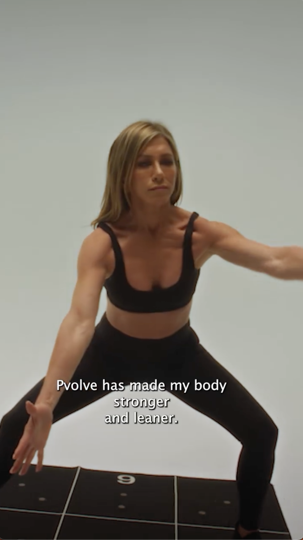 Jennifer Aniston realiza un movimiento similar a una sentadilla, involucrando su núcleo y la parte inferior del cuerpo como parte de un entrenamiento Pvolve | Fuente: Instagram/pvolve