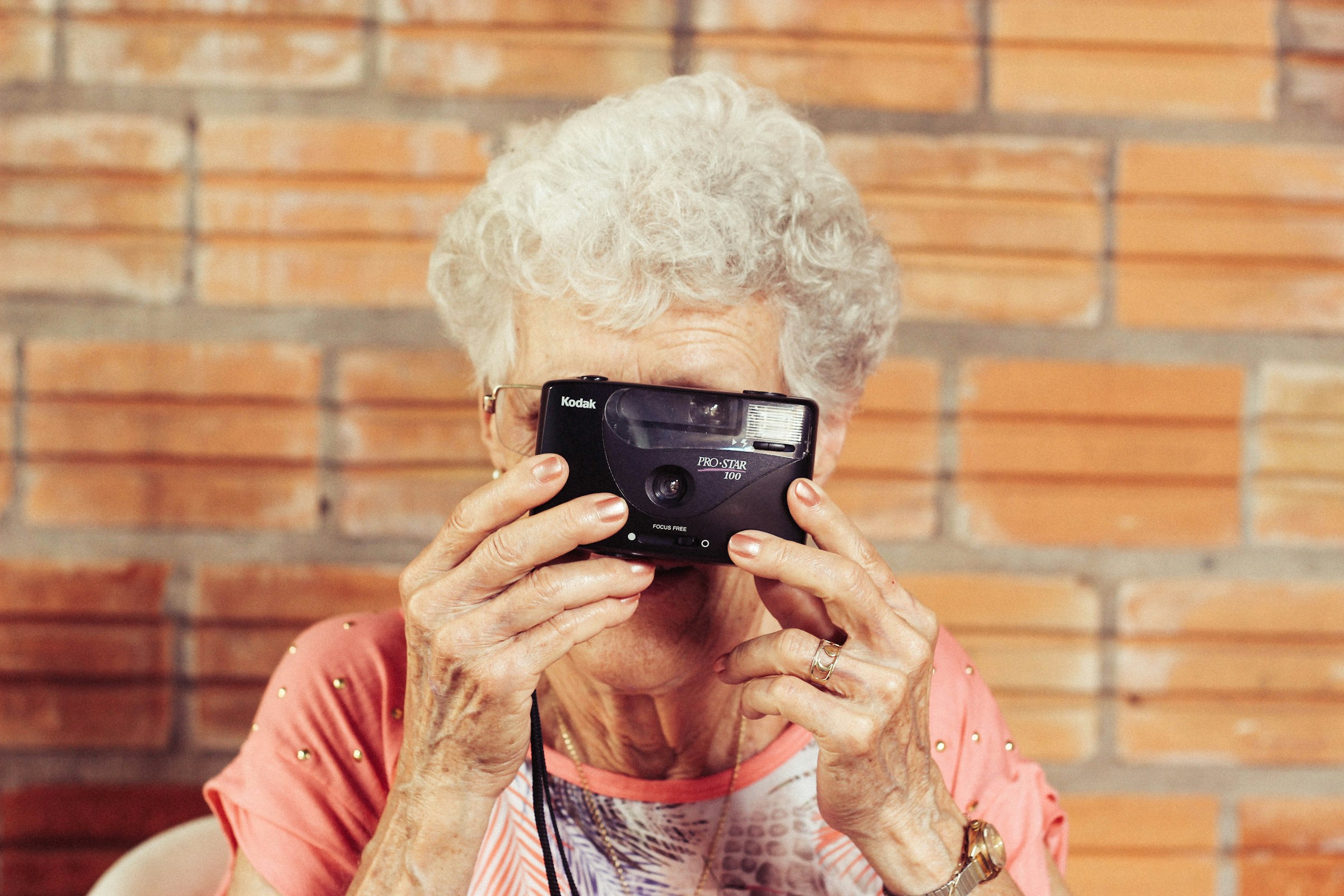 Una anciana sujetando una cámara | Fuente: Unsplash