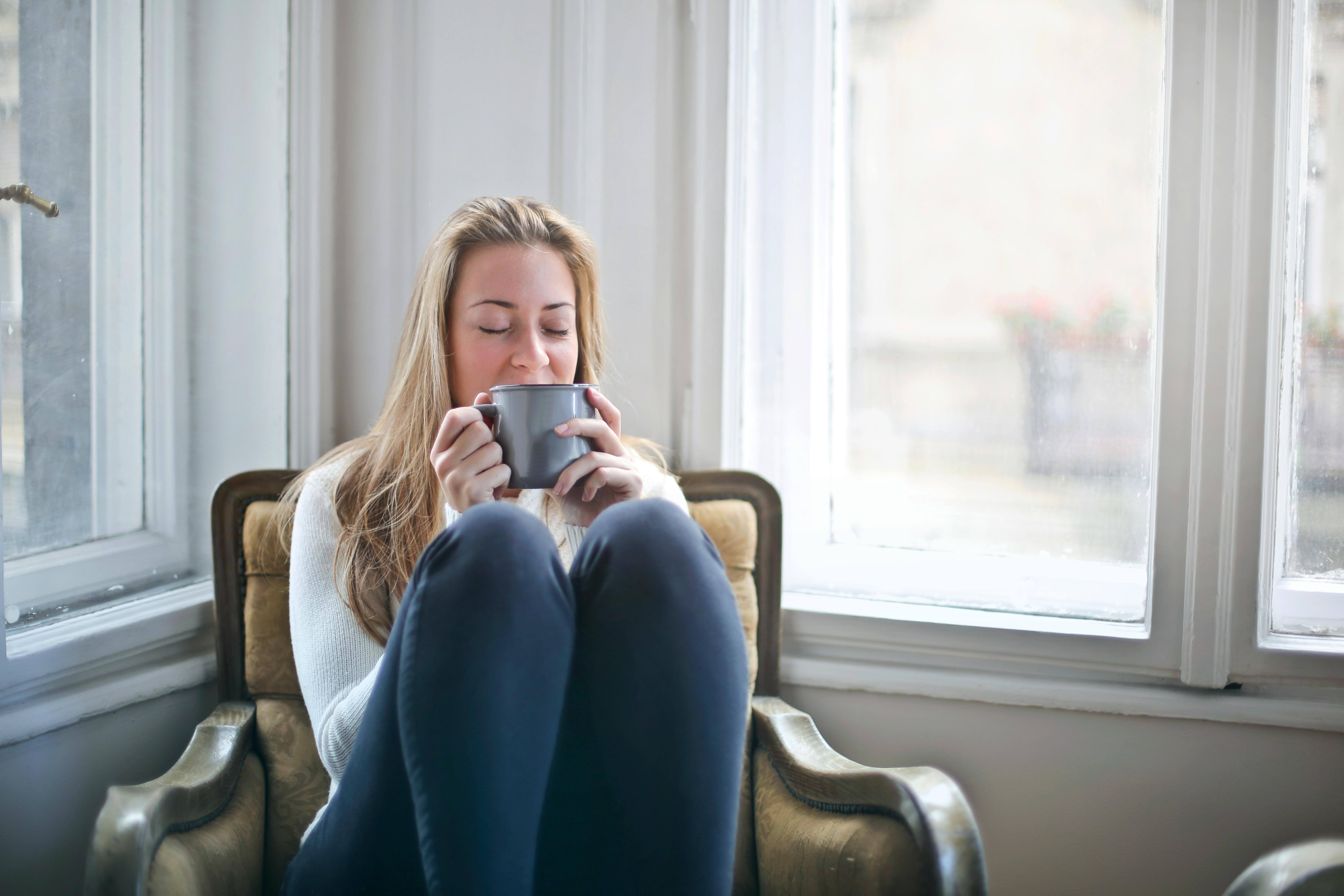 Una mujer disfrutando de una taza de té en casa | Fuente: Pexels