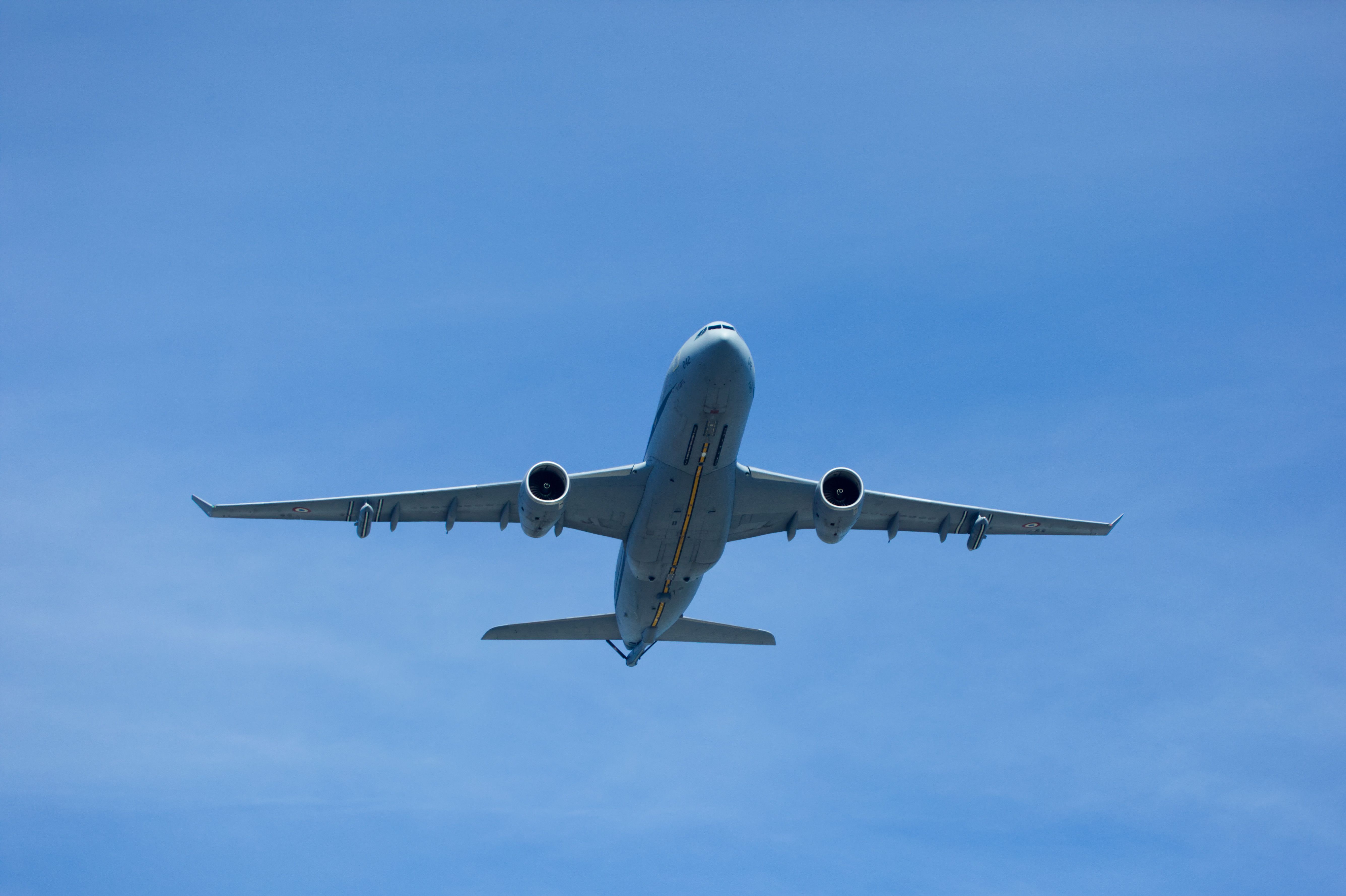 Avión fotografiado en vuelo contra un cielo azul y despejado | Fuente: Pexels
