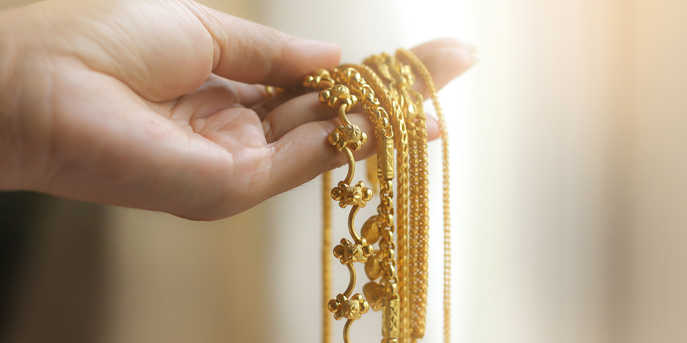 La mano de una mujer sosteniendo una joya de oro | Fuente: Shutterstock