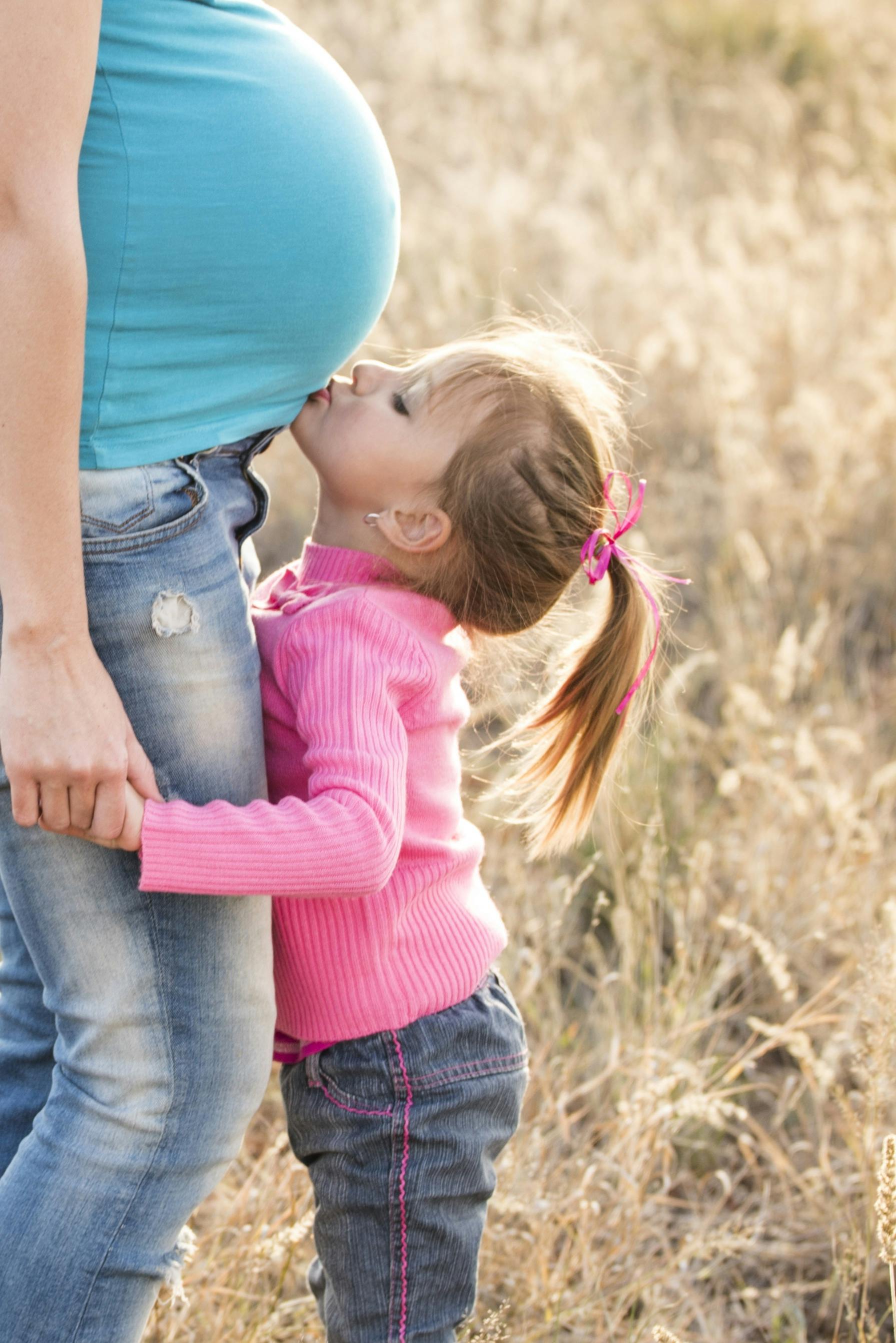 Niña besando una barriga de embarazada | Fuente: Pexels