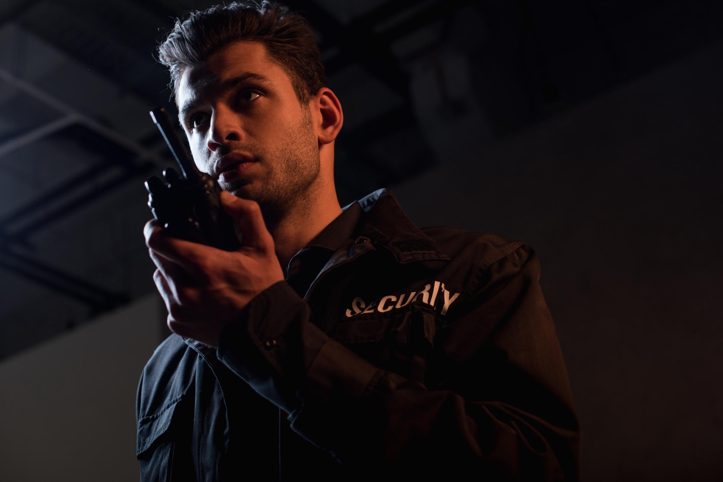 Guardia de seguridad utilizando un walkie talkie | Fuente: Shutterstock