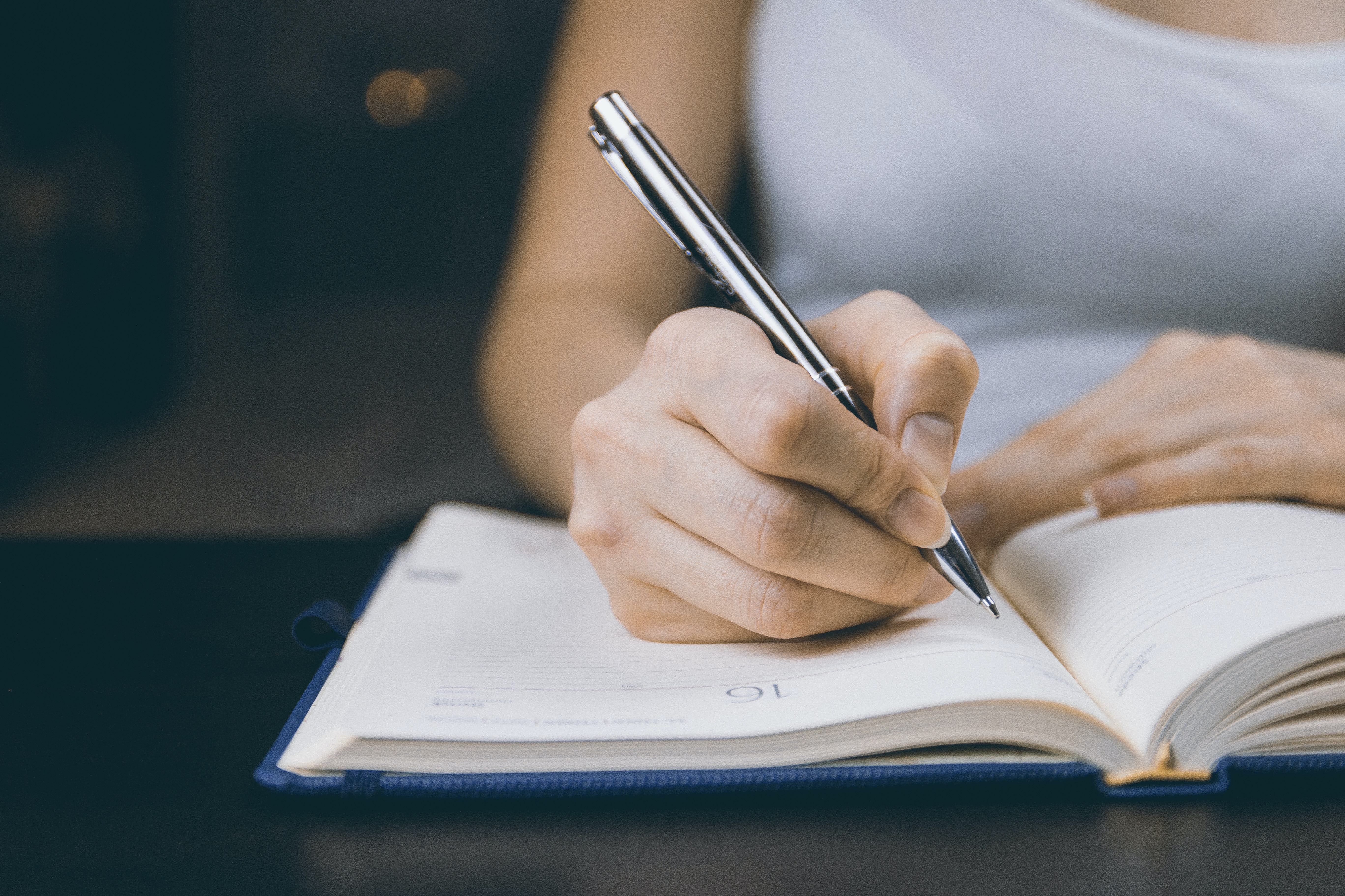 Primer plano de una mujer escribiendo en un cuaderno. | Foto: Pexels