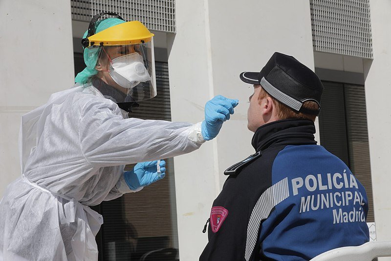 Trabajadora de la salud hace prueba diagnóstica de coronavirus a un policía municipal de Madrid. | Foto: Wikipedia