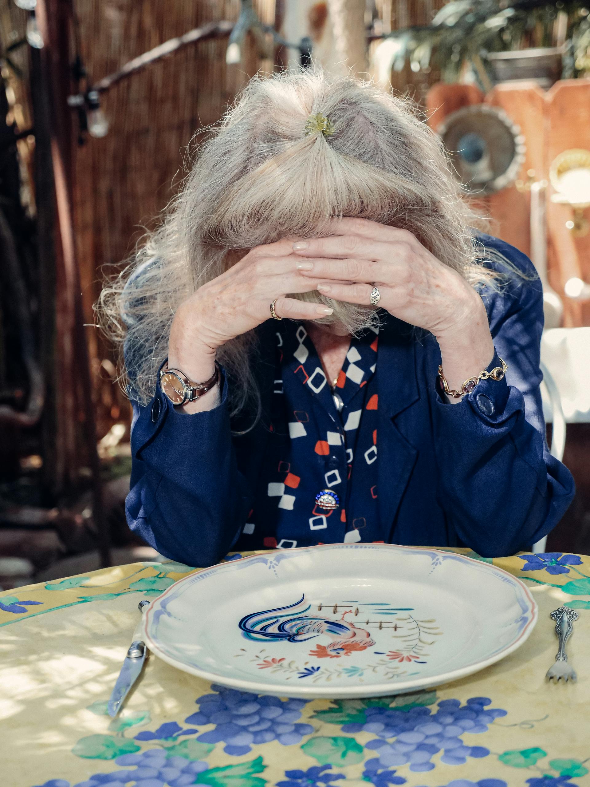 Una anciana triste tapándose la cara | Fuente: Pexels