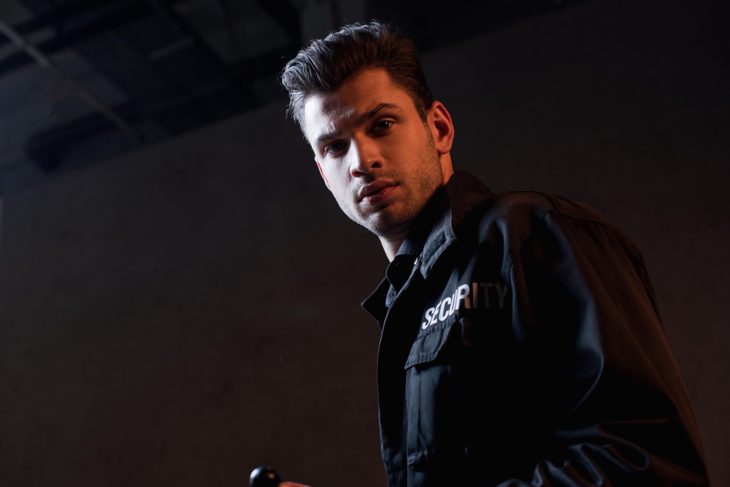 Guardia de seguridad mirando a alguien fuera de cámara | Fuente: Shutterstock