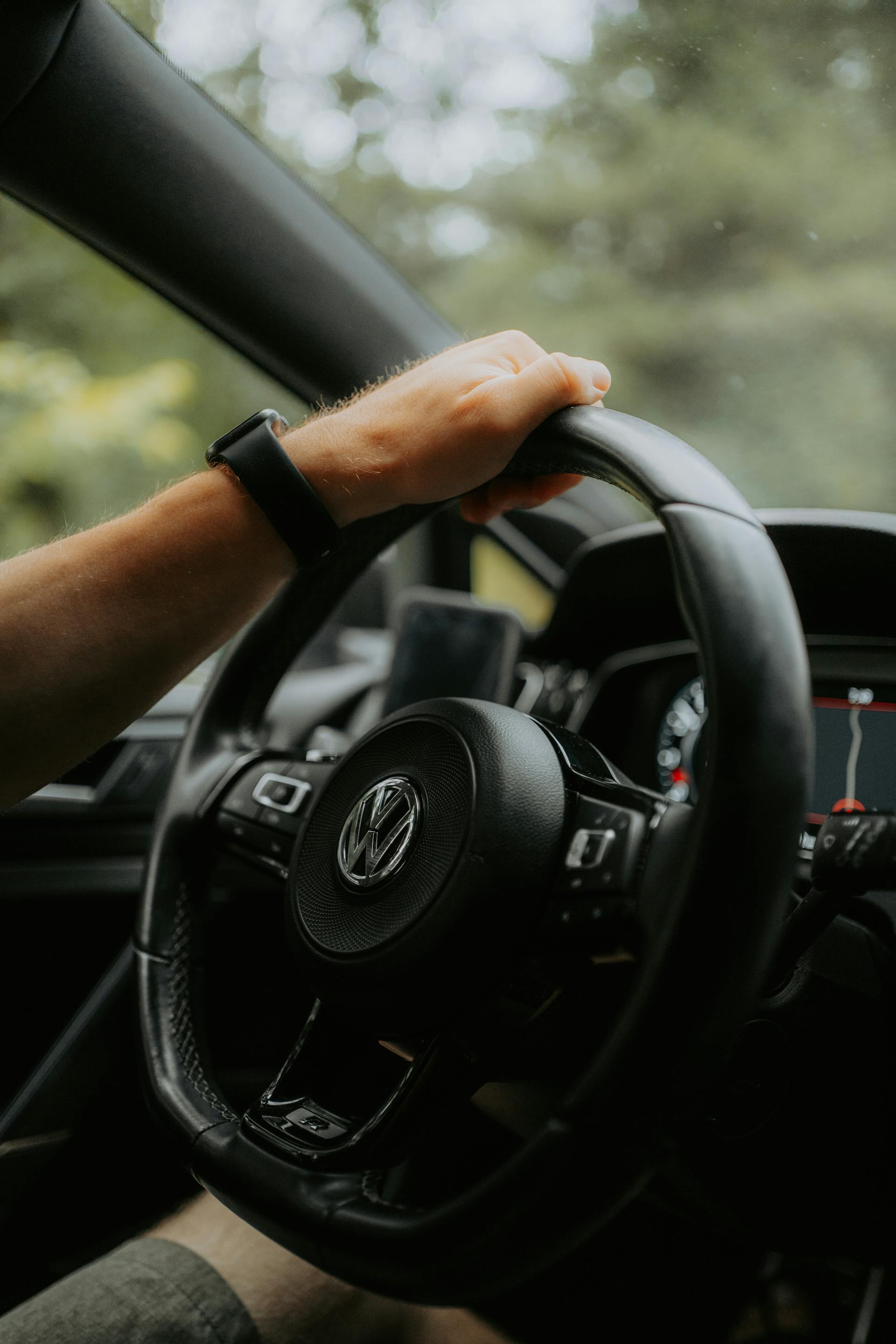 Un hombre sujeta con una mano el volante de un Automóvil Volkswagen | Fuente: Pexels