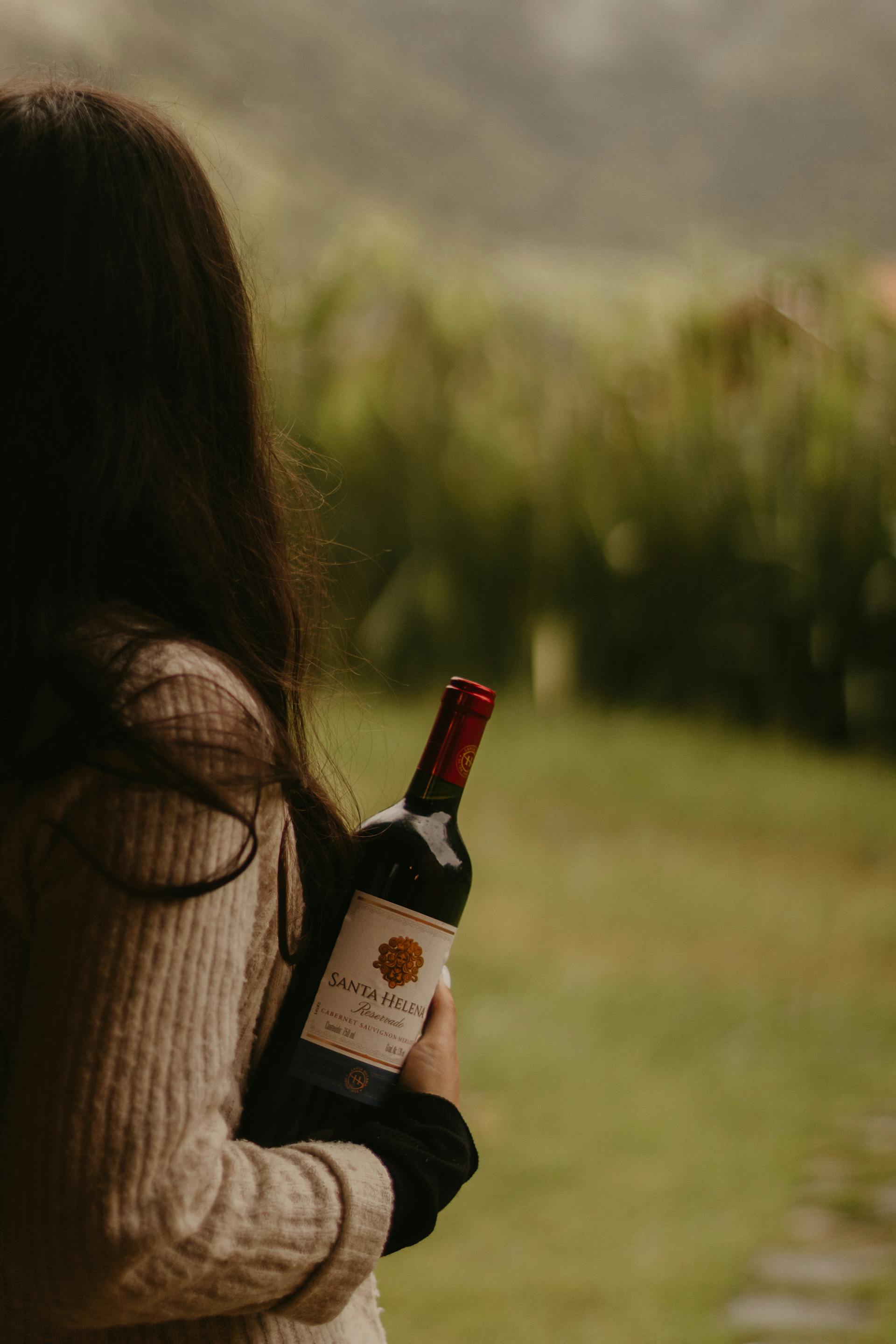 Una mujer con una botella de vino en la mano | Fuente: Pexels