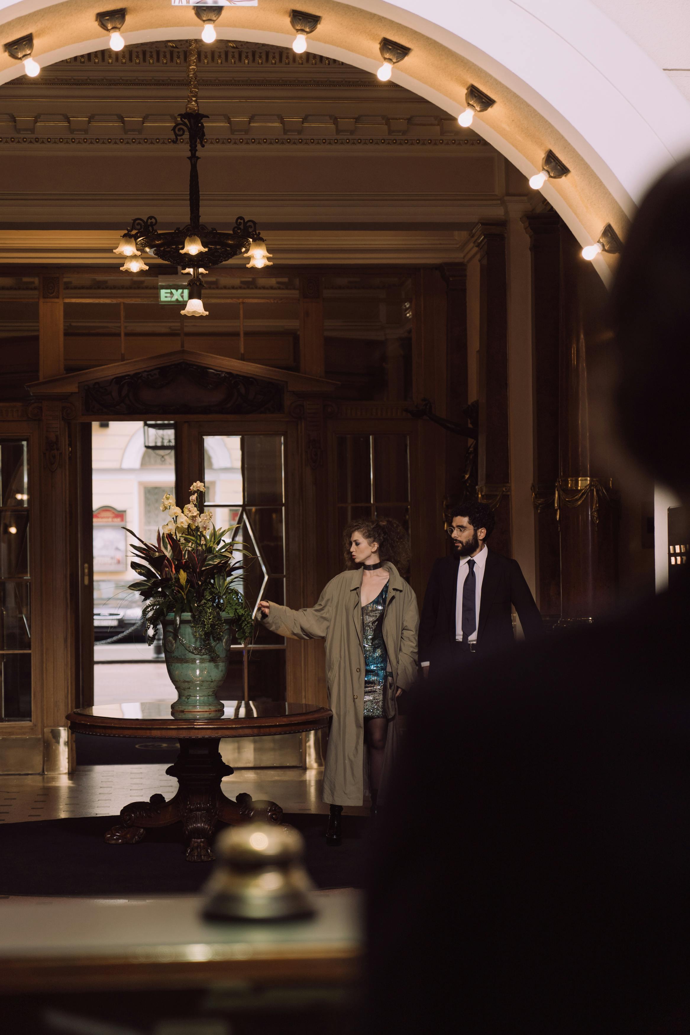 Hombre y mujer de pie en el vestíbulo de un hotel | Fuente: Pexels